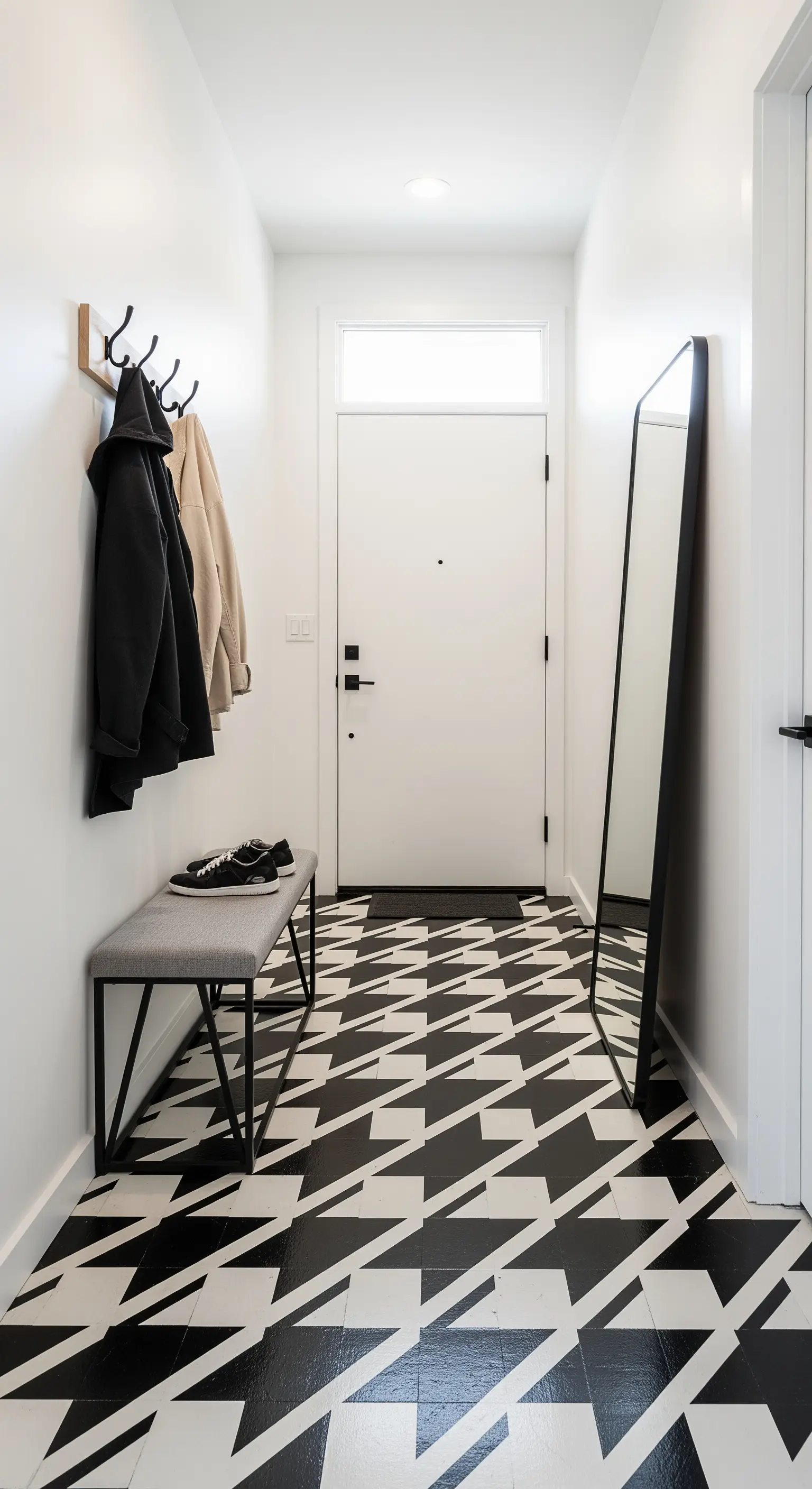 Ingresso stretto con un pavimento optical bianco e nero molto audace e arredi minimali.