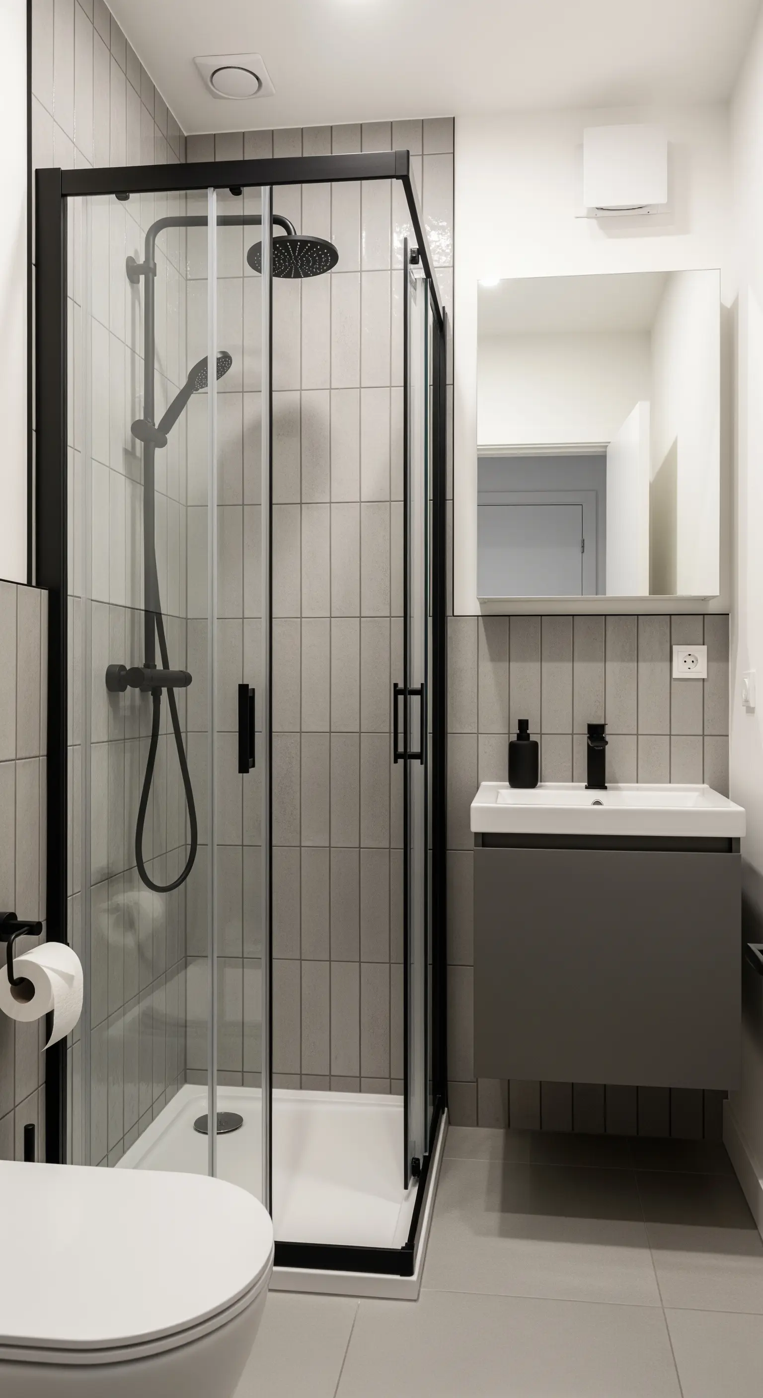 Bagno piccolo e funzionale con box doccia angolare con profili neri.