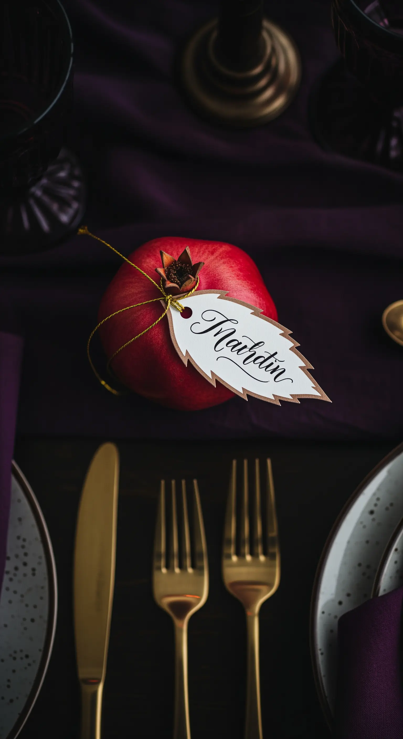 Melagrana rossa con un'etichetta a forma di foglia legata al picciolo.