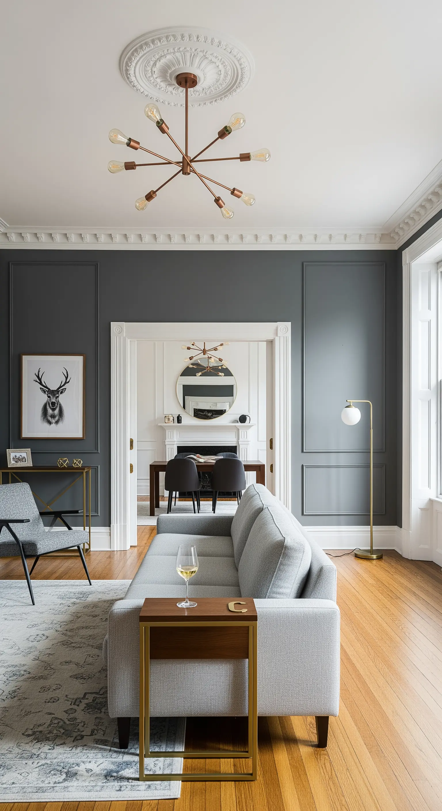 Salotto classico con pareti grigie, lampadario sputnik in rame e accenti dorati.