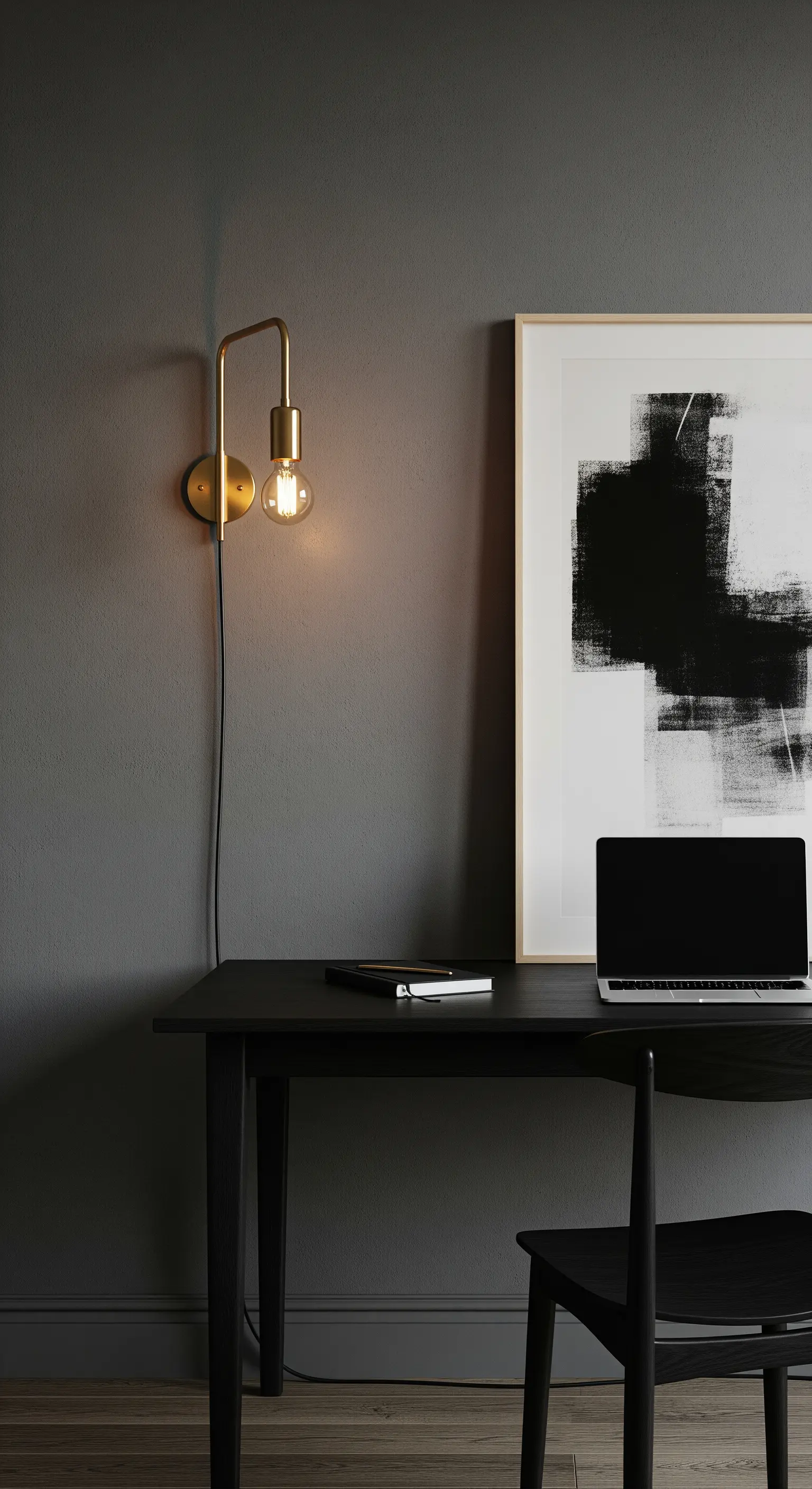 Lampada da parete in ottone con bulbo a vista sopra una scrivania nera minimale.
