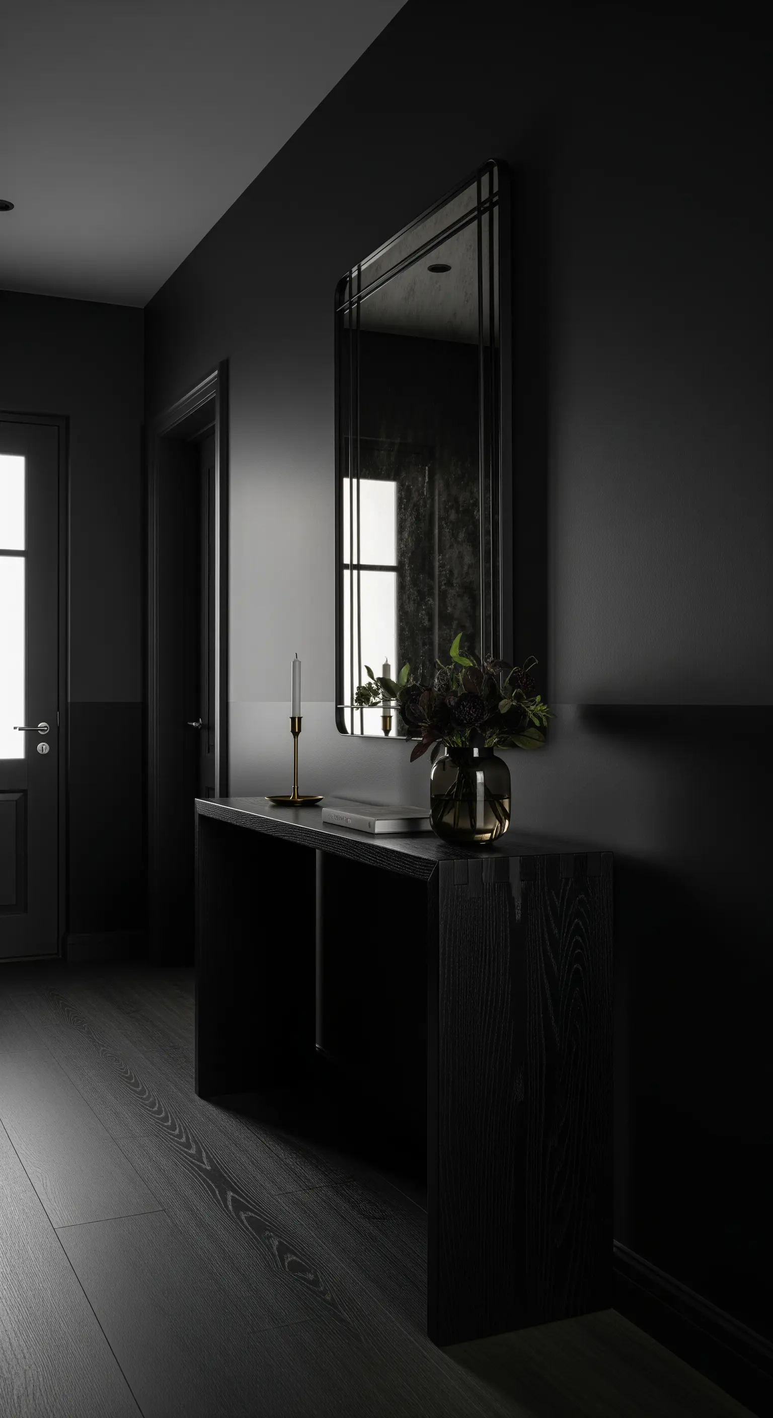 Ingresso total black con diverse finiture di nero e consolle in legno scuro.
