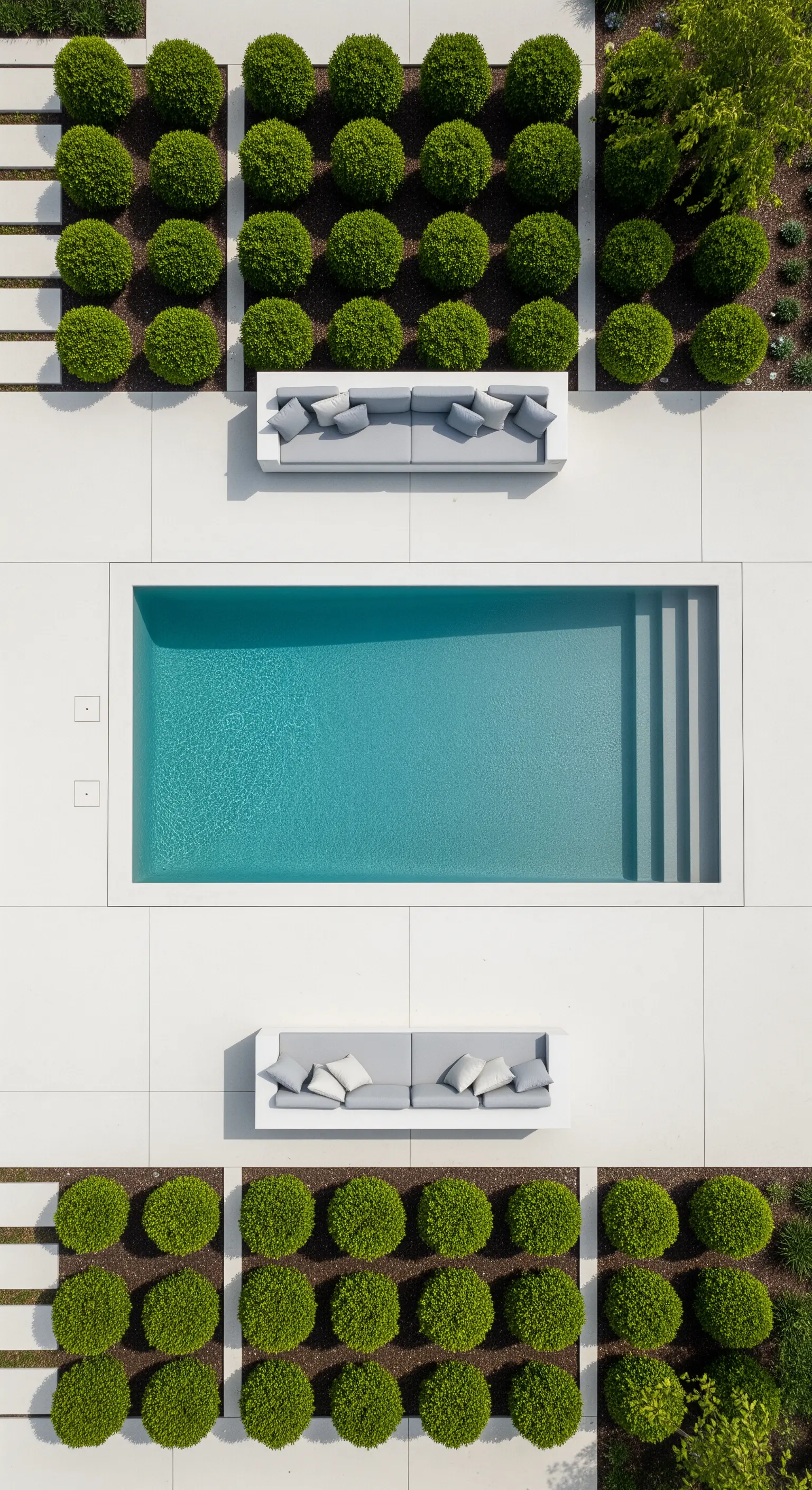 Vista aerea di una piscina rettangolare con due divani simmetrici e aiuole geometriche