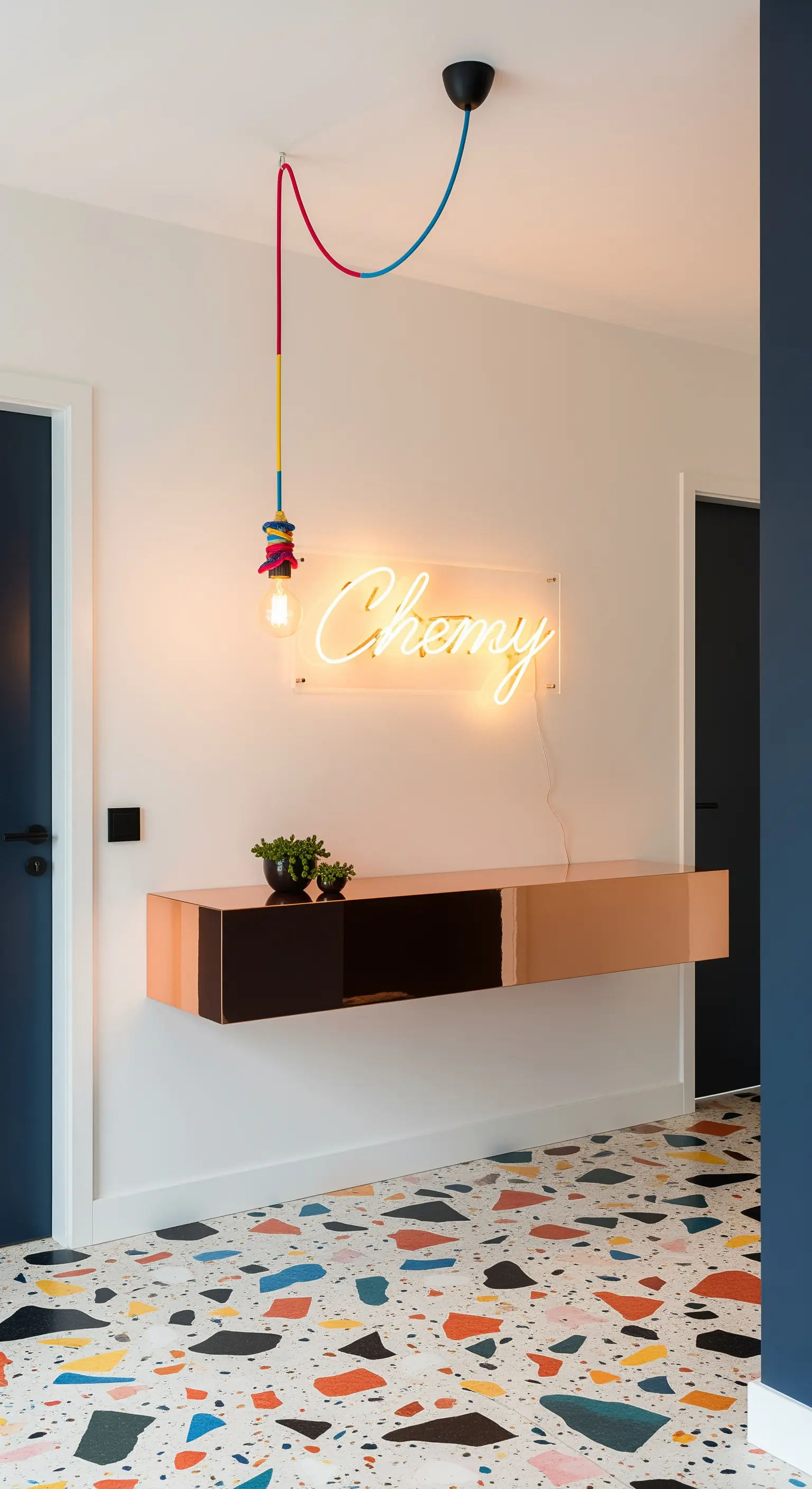 Ingresso con pavimento in terrazzo colorato, consolle in oro rosa e insegna al neon.