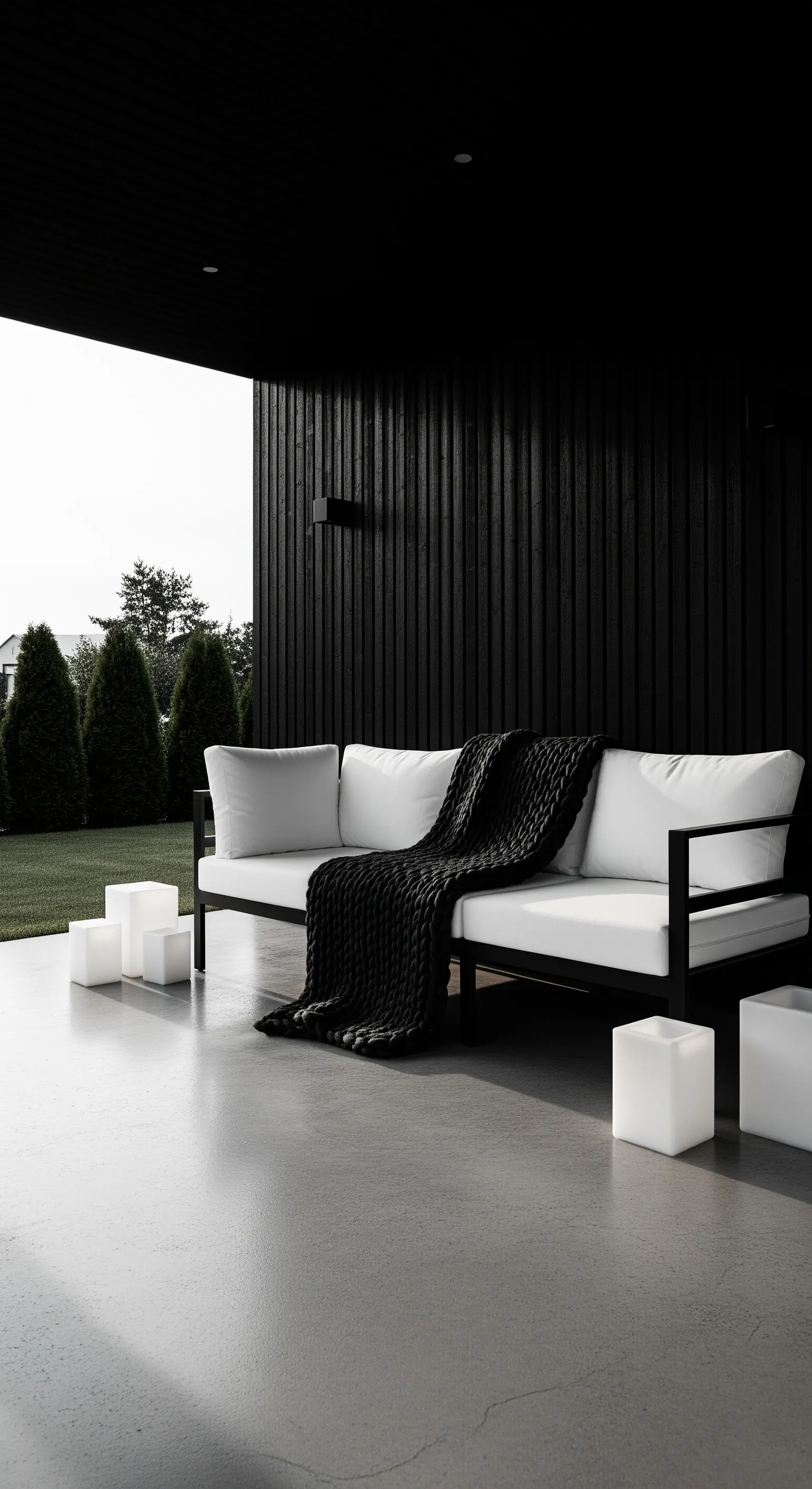 Patio minimalista con divano bianco, parete in legno nero e cubi luminosi a LED.