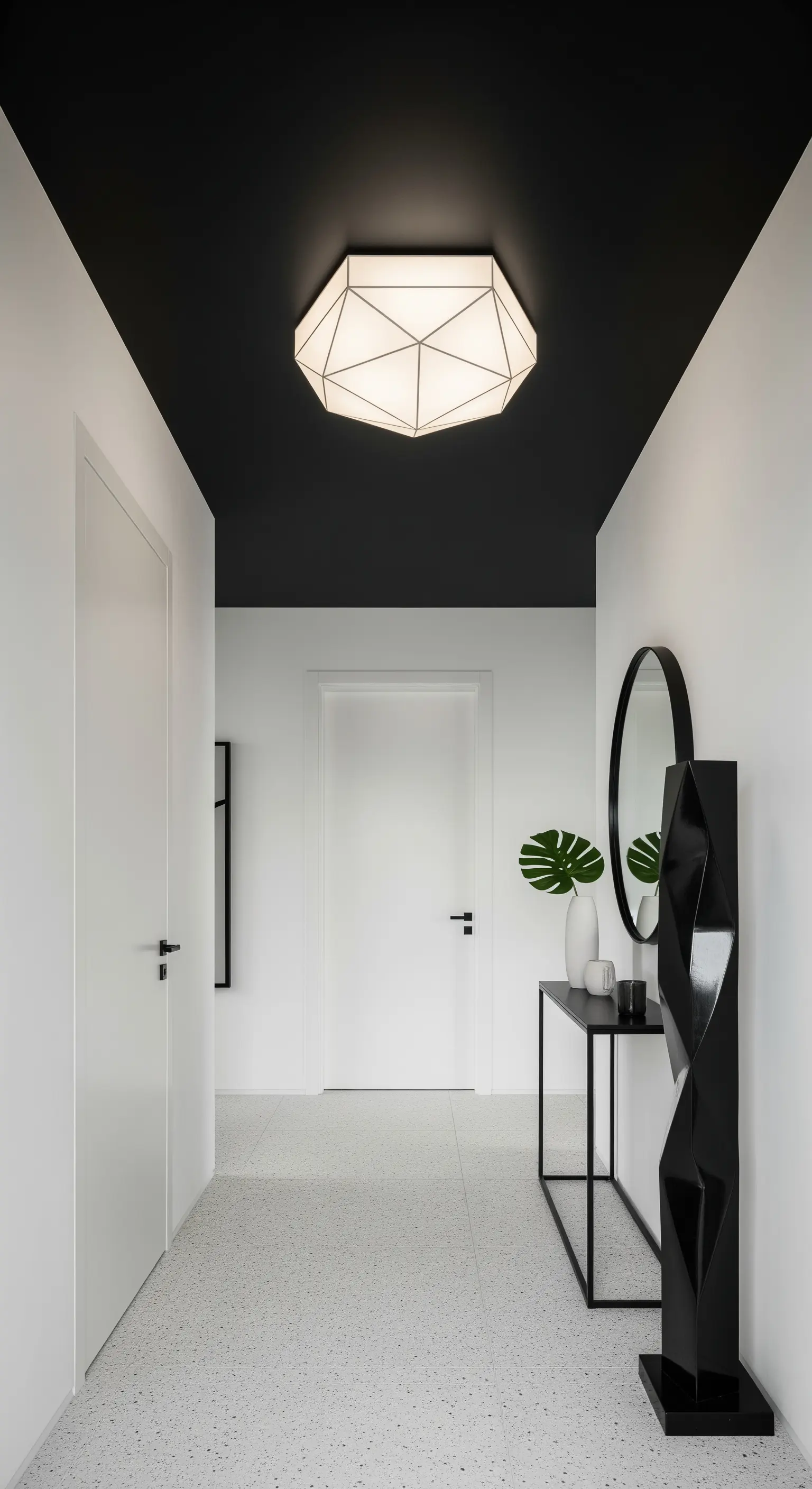 Corridoio con pareti bianche e soffitto nero a contrasto, con un lampadario geometrico bianco.
