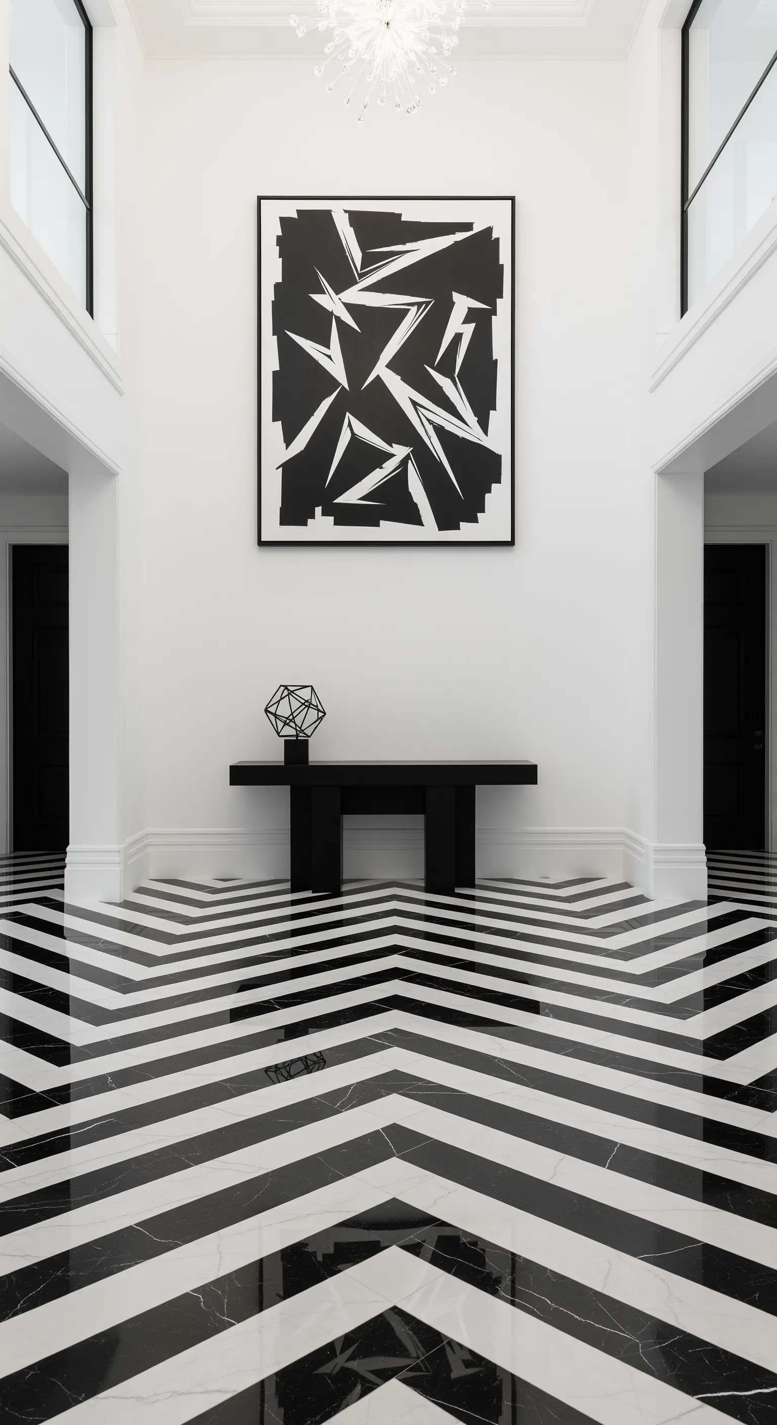 Ingresso con pavimento in marmo lucido a chevron bianco e nero e una console nera minimalista.