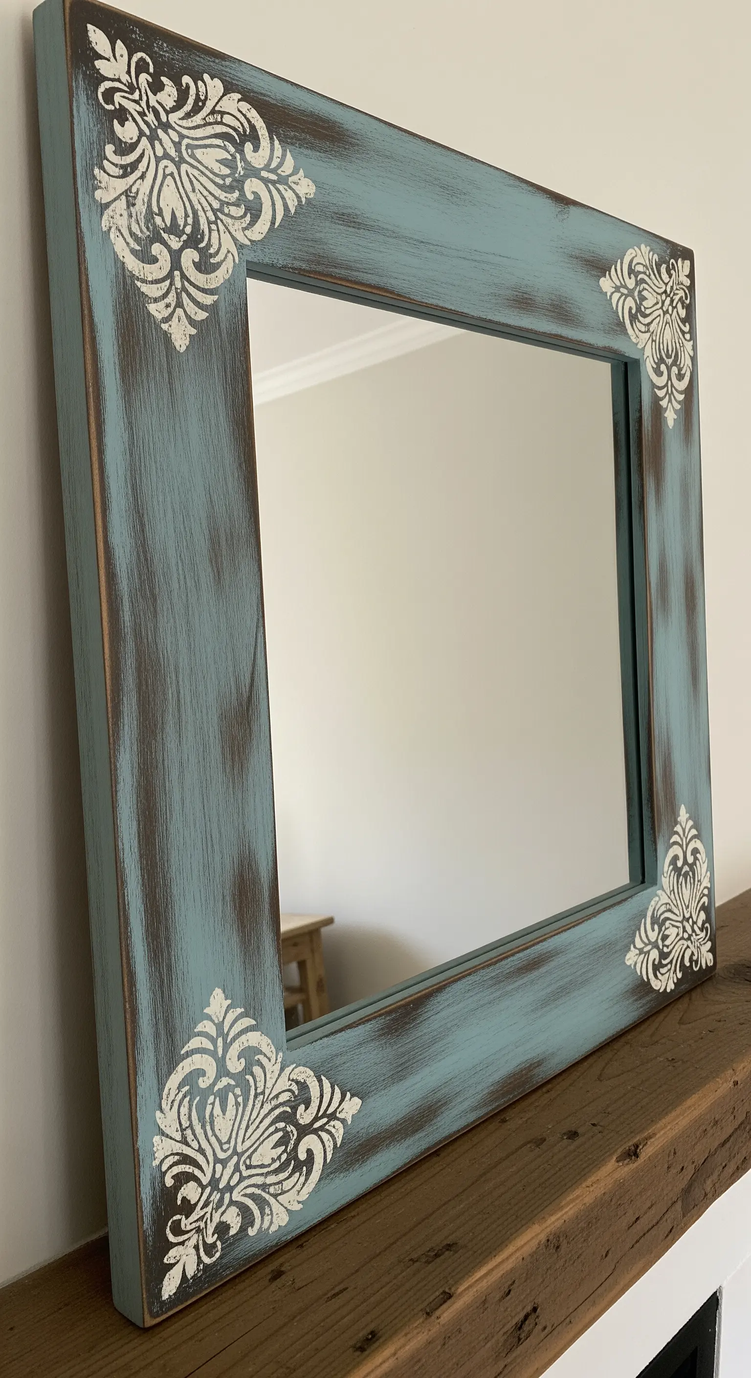 Cornice rettangolare in legno dipinta di blu e invecchiata, con decorazioni a stencil bianche.