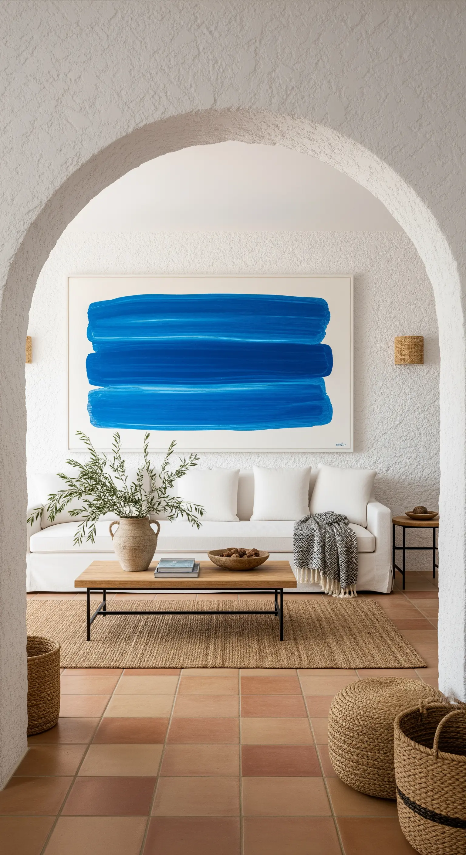Grande quadro con tre pennellate di blu intenso su una parete bianca in un soggiorno mediterraneo.