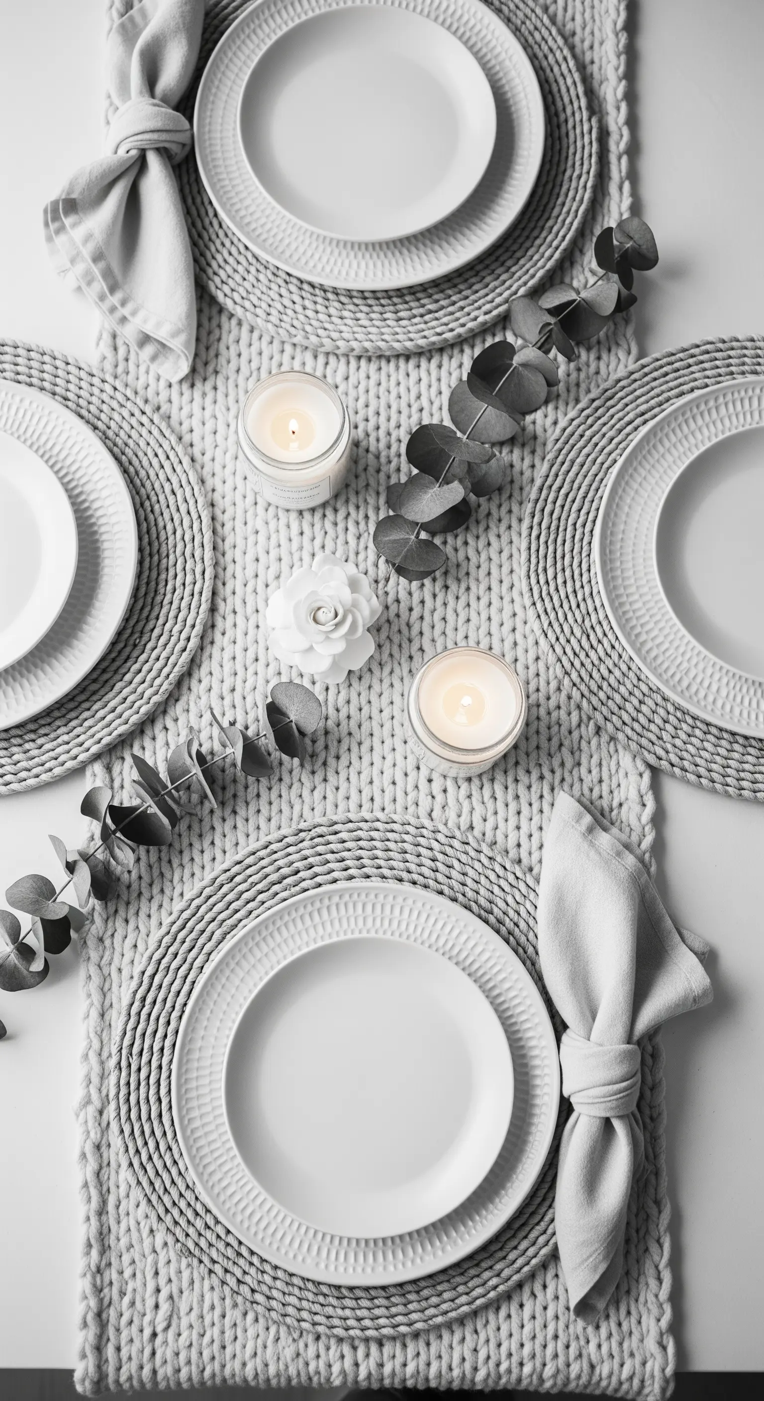 Tavola total white con runner a maglia, piatti a rilievo ed eucalipto