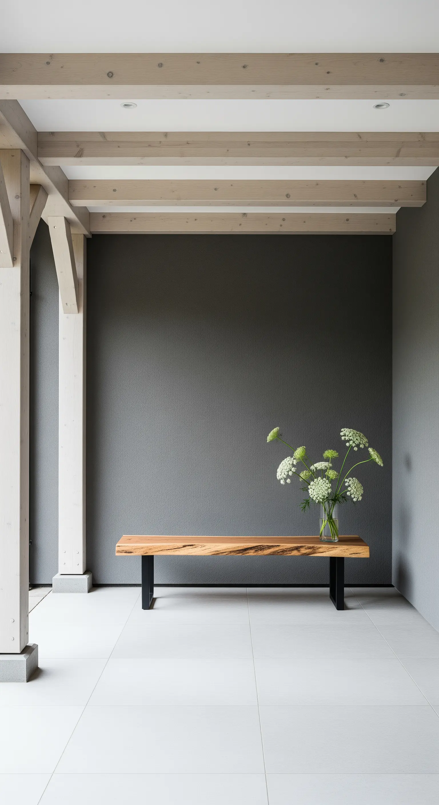 Portico moderno con parete grigia, travi chiare e panca di design in legno con fiori bianchi.
