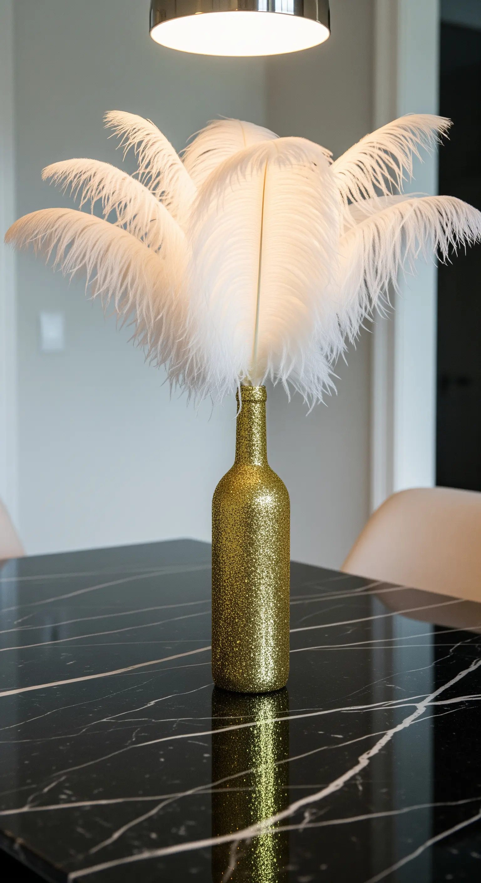 Bottiglia di vino dorata ricoperta di glitter con un bouquet di piume bianche.