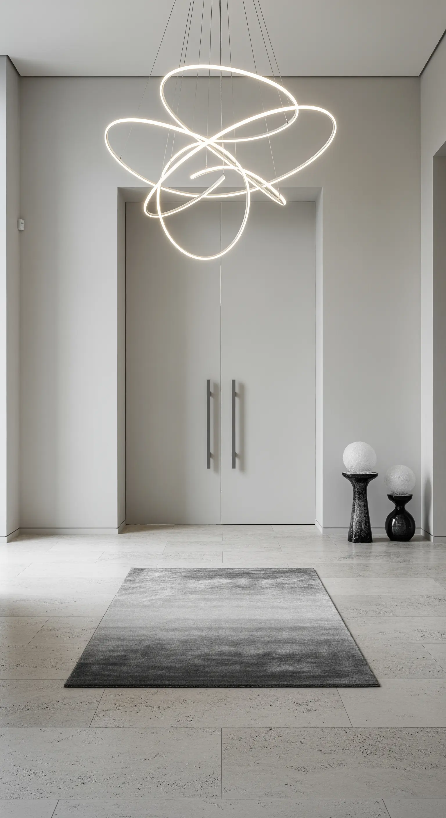 Atrio minimalista con lampadario a LED scultoreo e tappeto grigio sfumato.