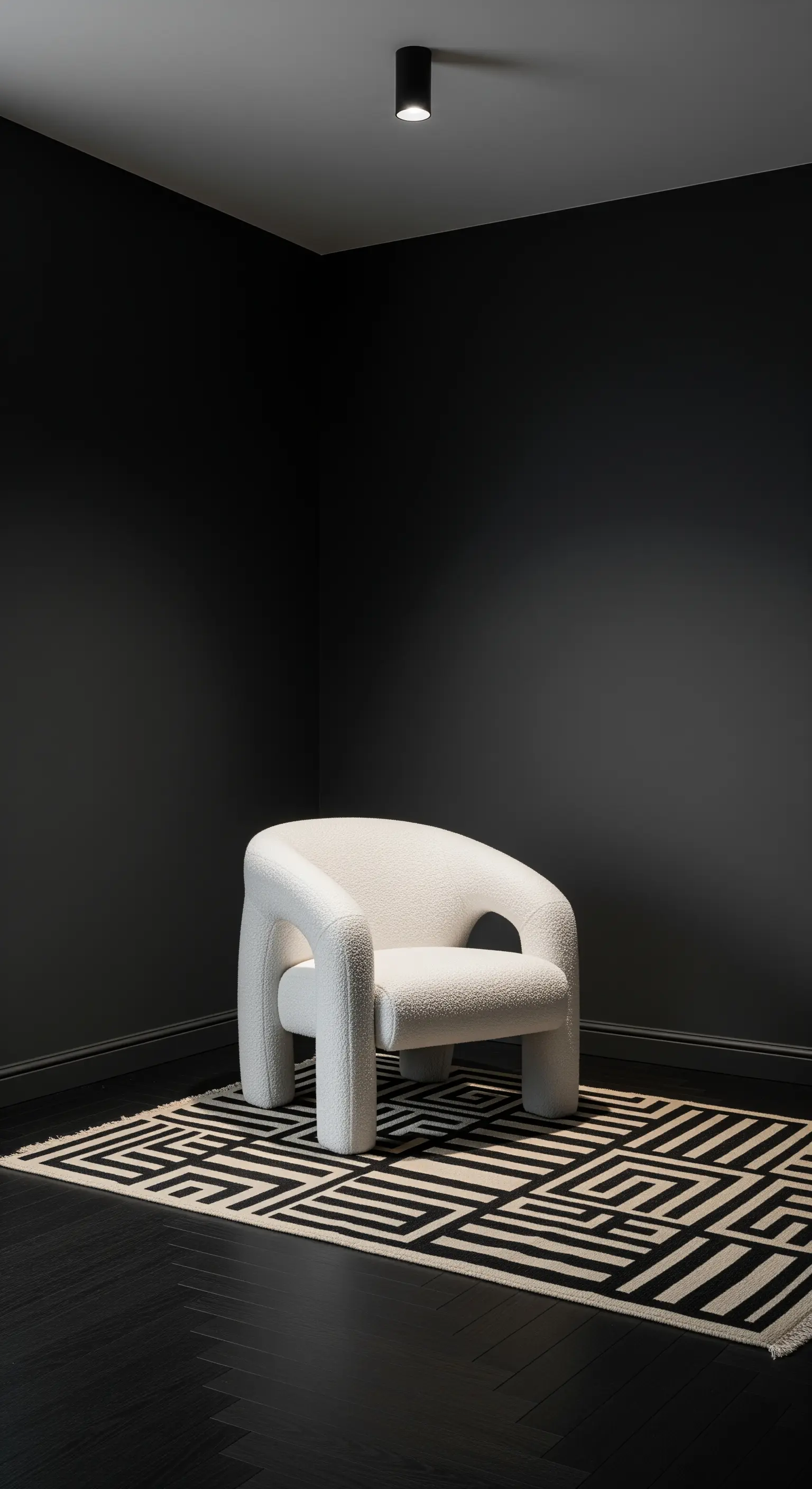 Poltrona bianca scultorea in un angolo completamente nero, su un tappeto geometrico.