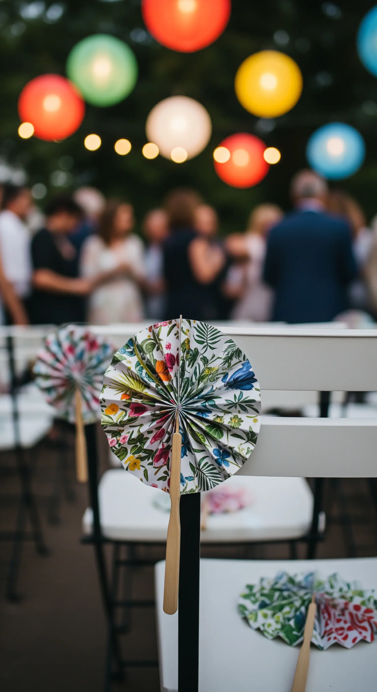 Ventagli di carta con motivi floreali appoggiati su sedie bianche