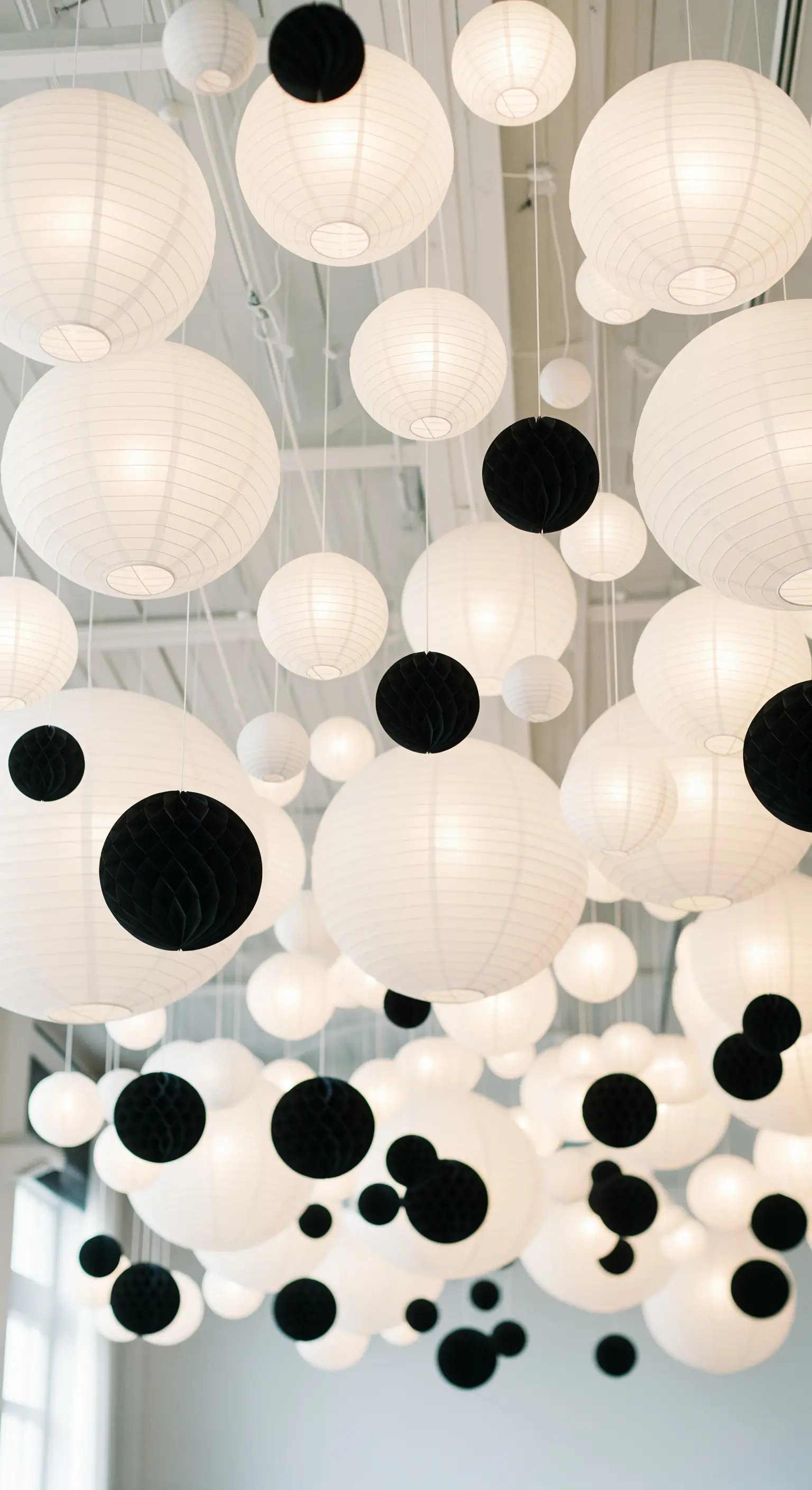 Soffitto decorato con una moltitudine di lanterne di carta bianche e nere.