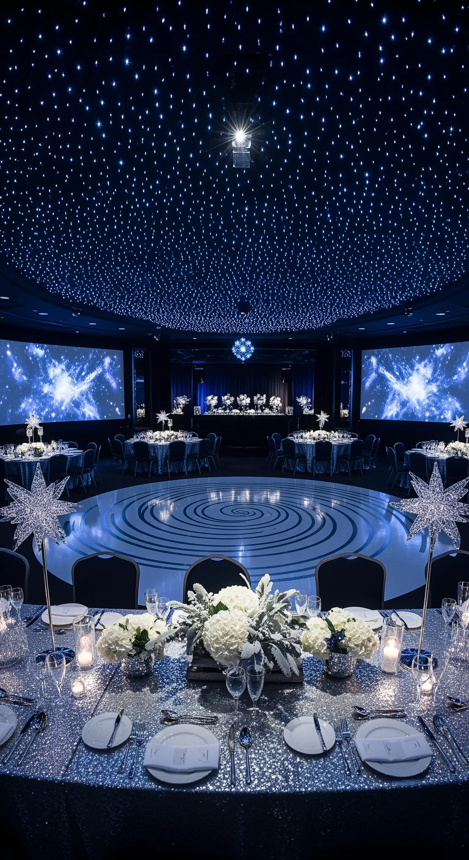 Sala ricevimenti con soffitto stellato, tavoli argento e decorazioni a forma di stella.