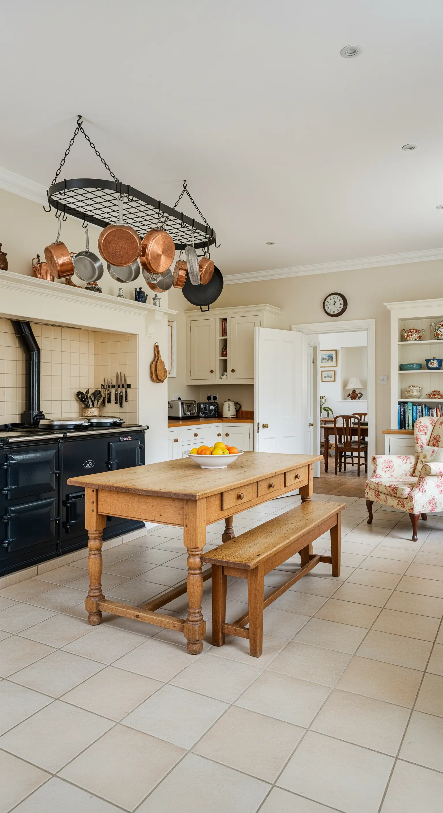 Cucina country con grande tavolo in legno, panca e griglia portapentole in rame sospesa.