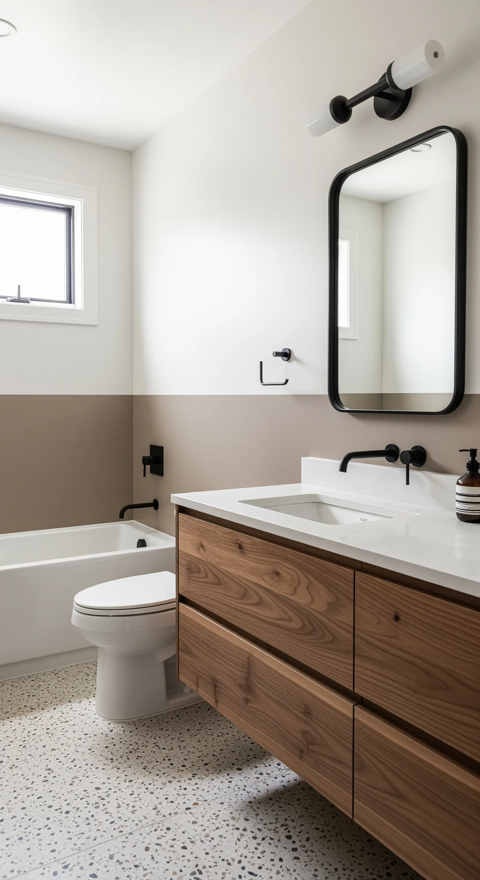 Bagno moderno con parete color tortora, mobile in noce e pavimento in terrazzo.