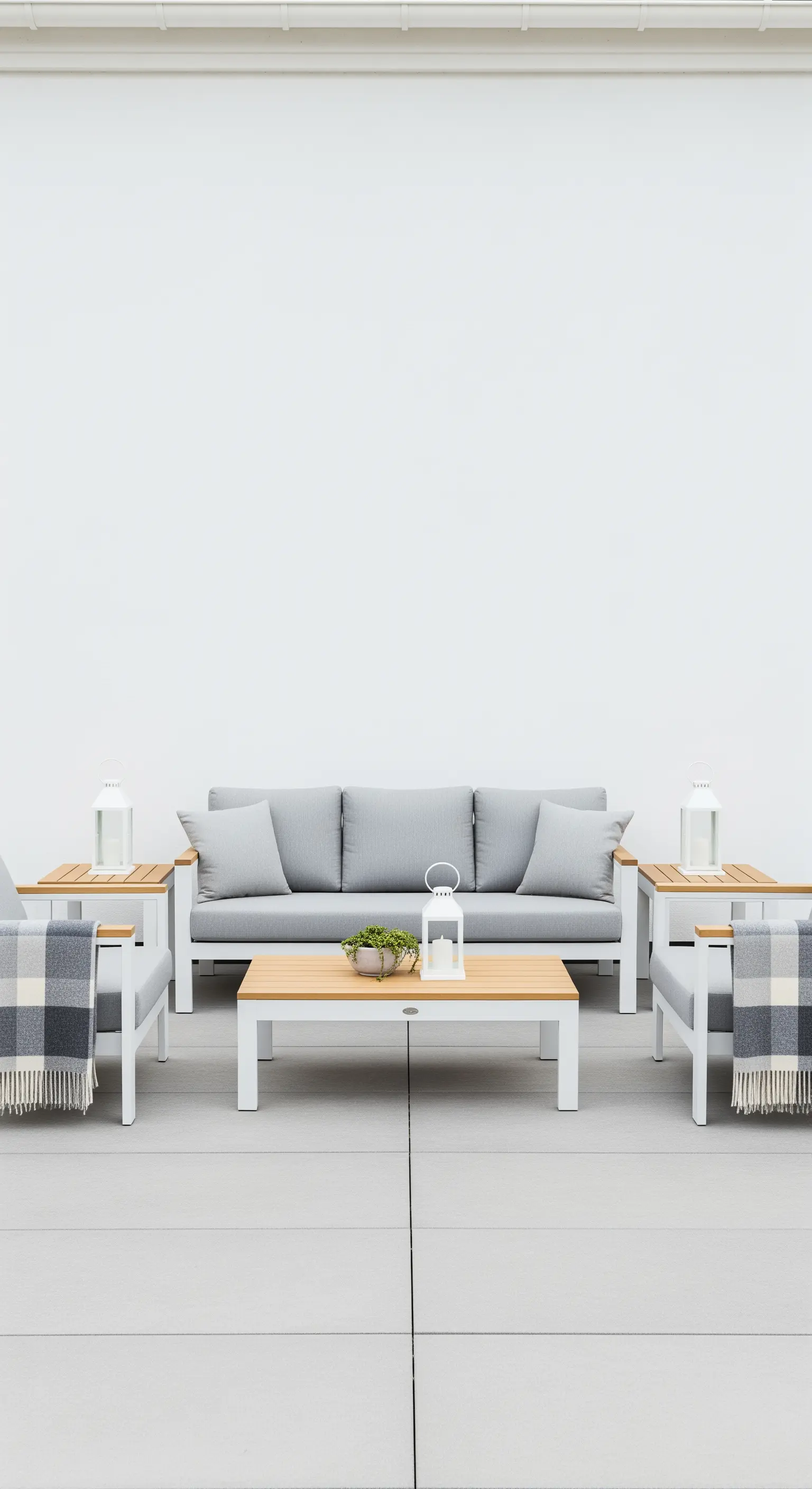 Set di arredi da giardino grigi disposti in modo simmetrico su una pavimentazione chiara.