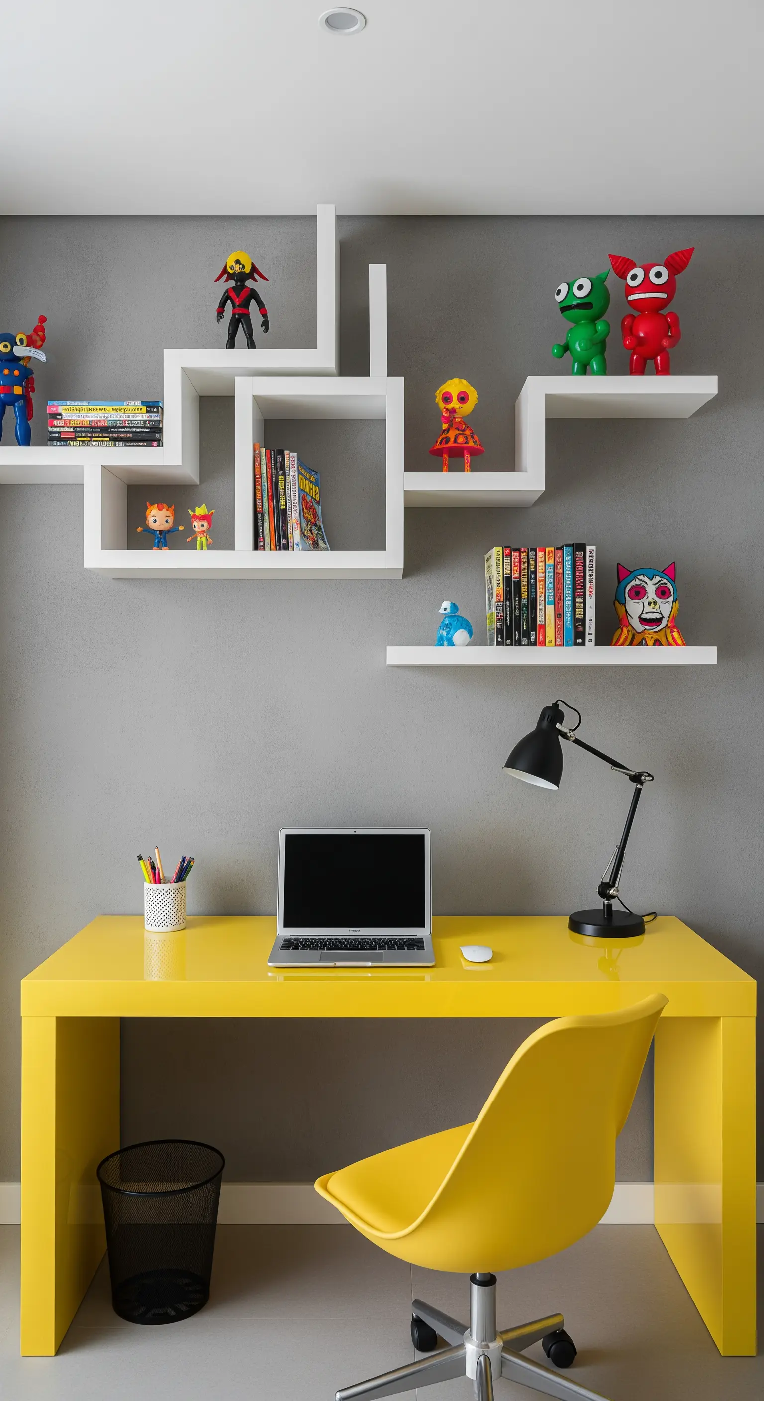 Scrivania e sedia gialle abbinate a mensole geometriche bianche su parete grigia.
