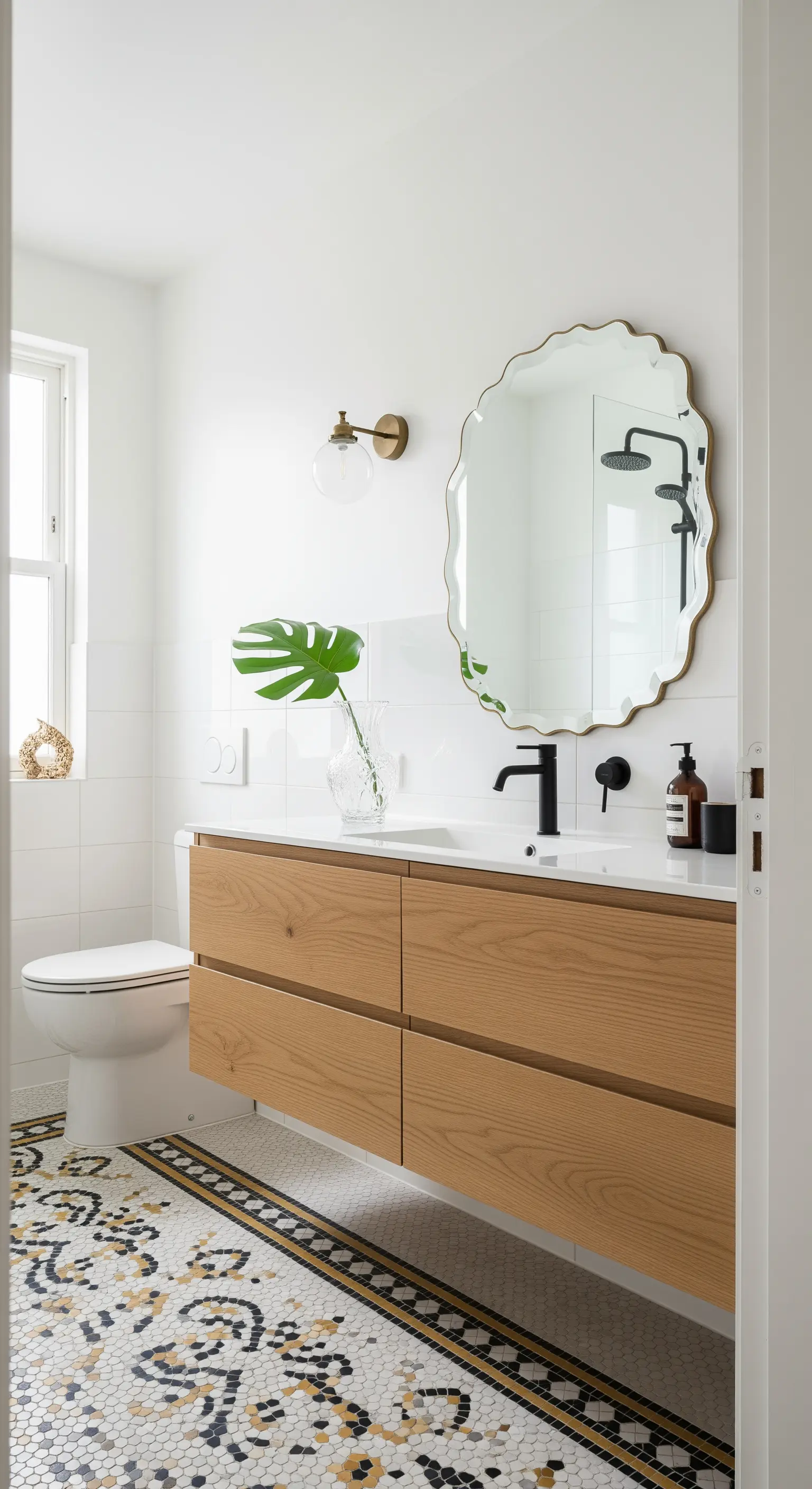 Mobile bagno moderno in legno chiaro su un pavimento a mosaico vintage in bianco, nero e oro.