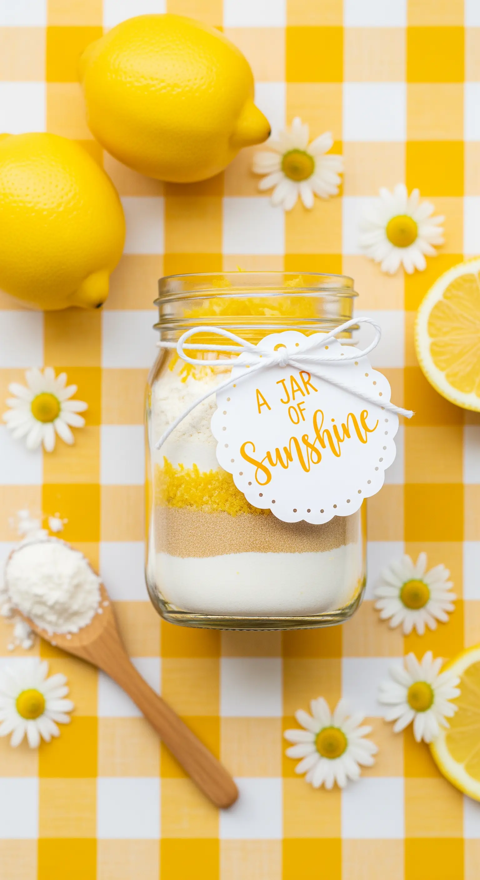 Barattolo di vetro con preparato per dolci al limone su una tovaglia a quadri gialla.