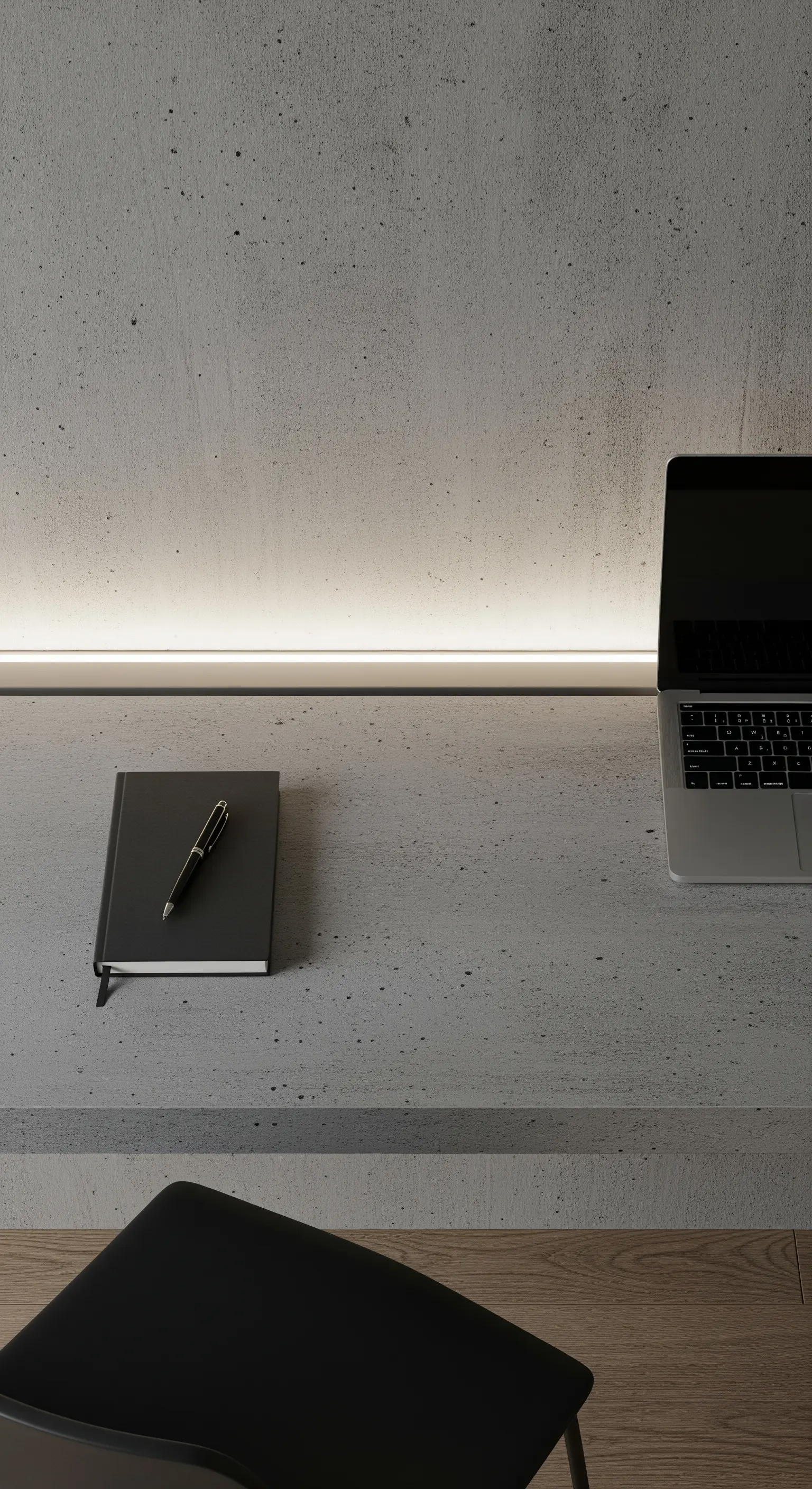 Scrivania in cemento con una sottile striscia LED integrata alla base della parete.