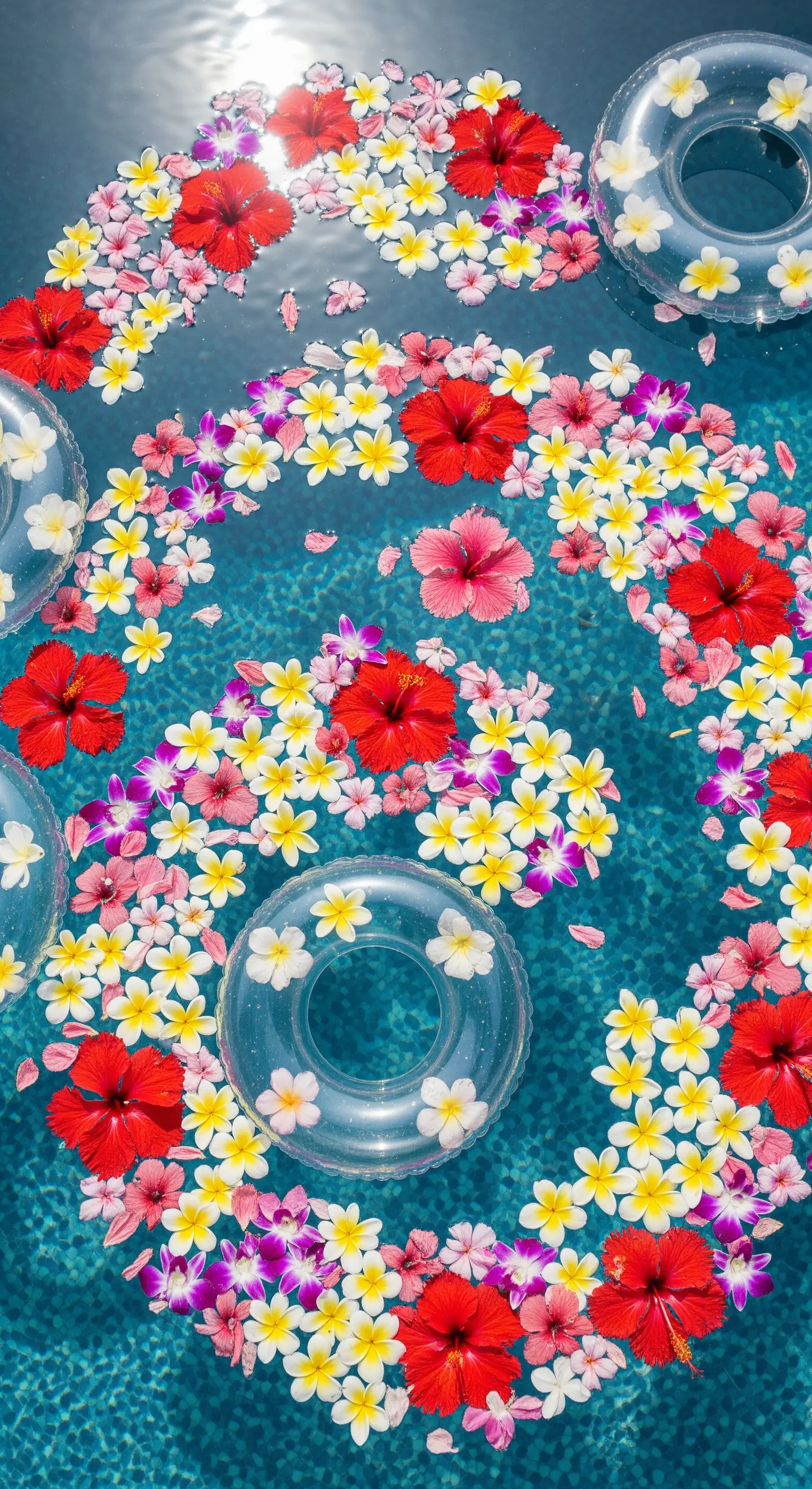 Piscina decorata con un cerchio di fiori tropicali colorati galleggianti, come ibisco e frangipani.