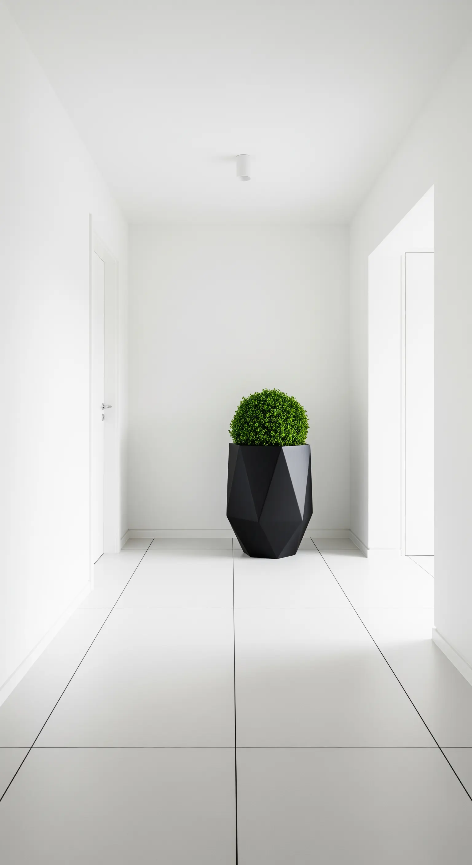 Corridoio minimalista total white con un unico grande vaso nero sfaccettato al centro.