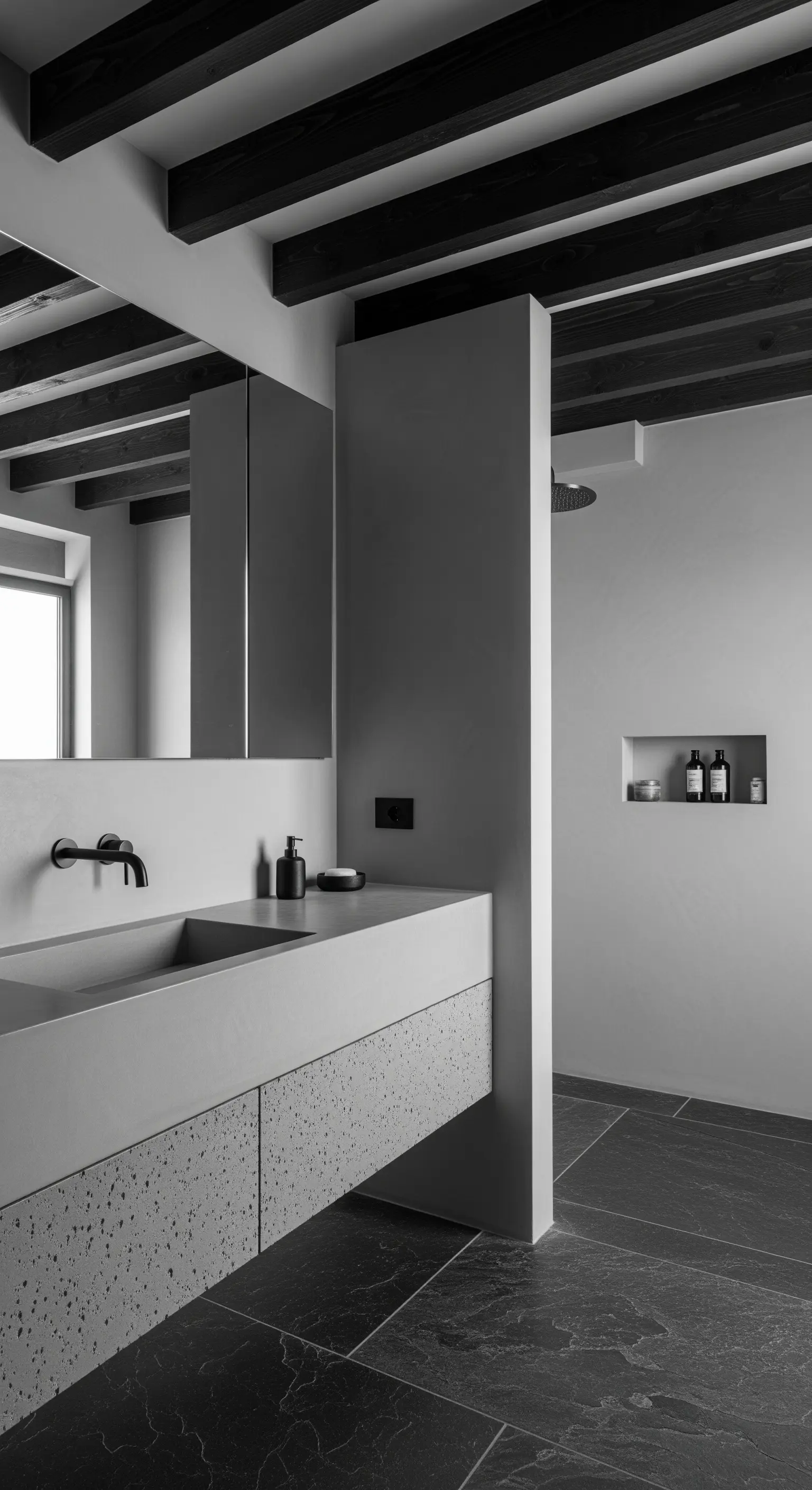 Bagno monocromatico grigio e nero con diverse texture: cemento, legno e terrazzo.