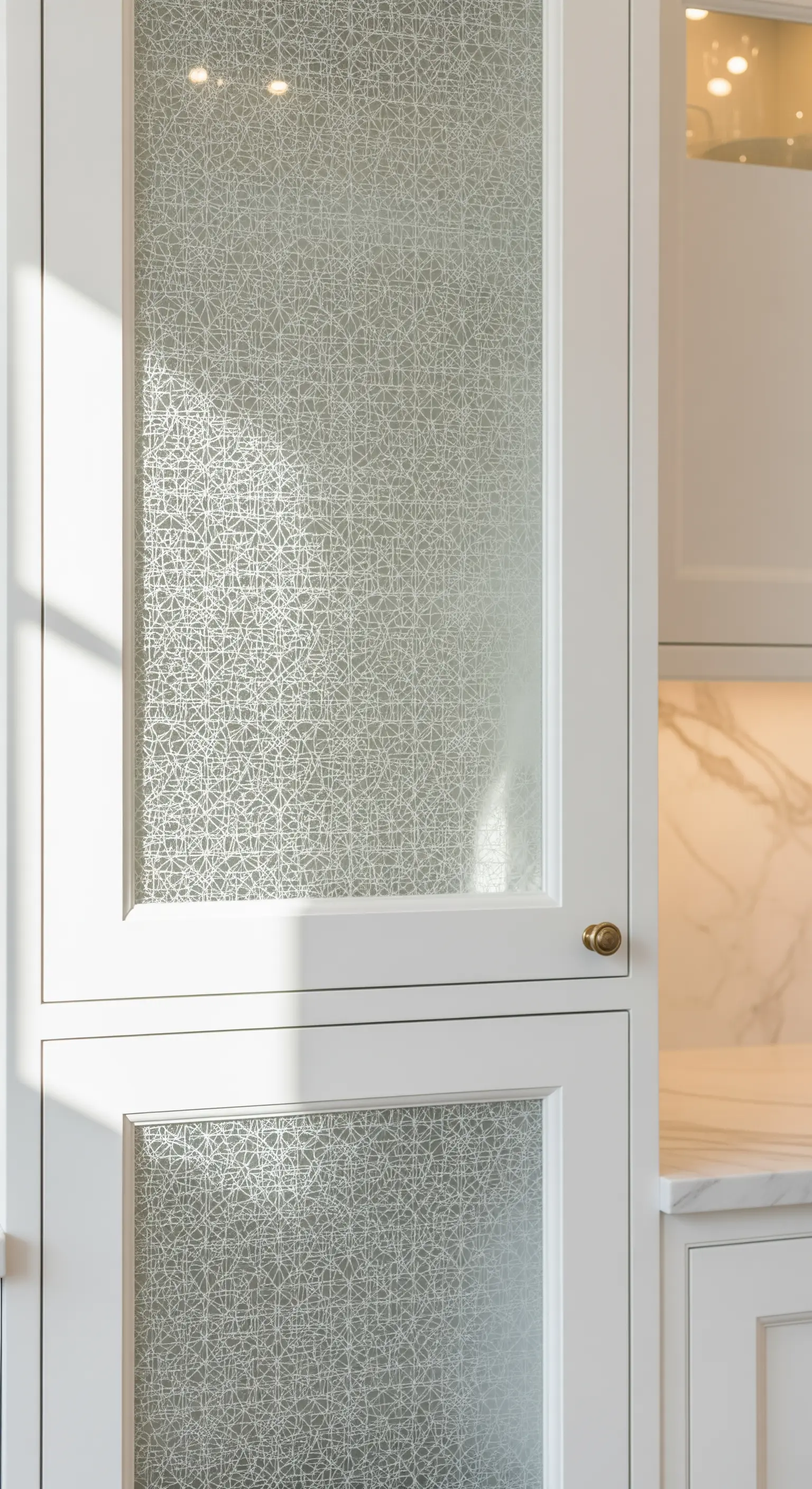 Anta di un mobile bianco con un inserto in vetro decorato a motivi geometrici.