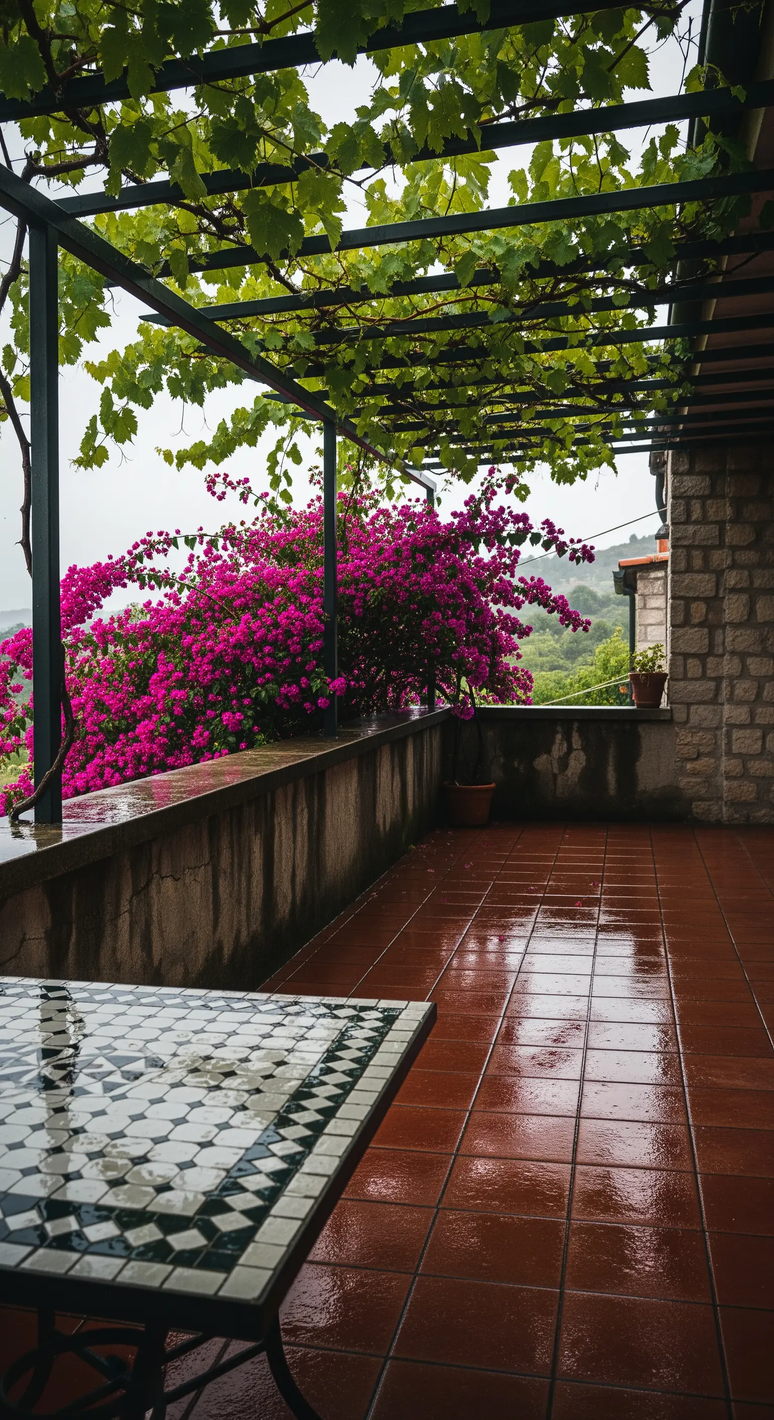 Veranda con pavimento in cotto bagnato dalla pioggia e tavolo in mosaico