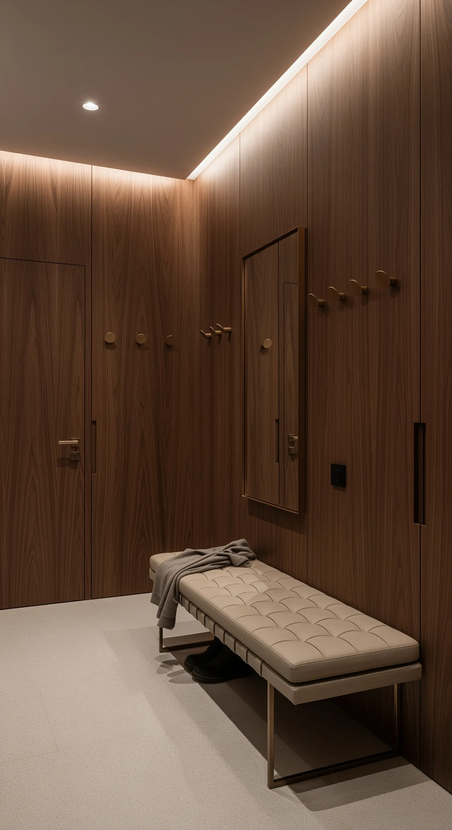 Ingresso interamente rivestito in legno di noce con panca in pelle chiara e ottone.