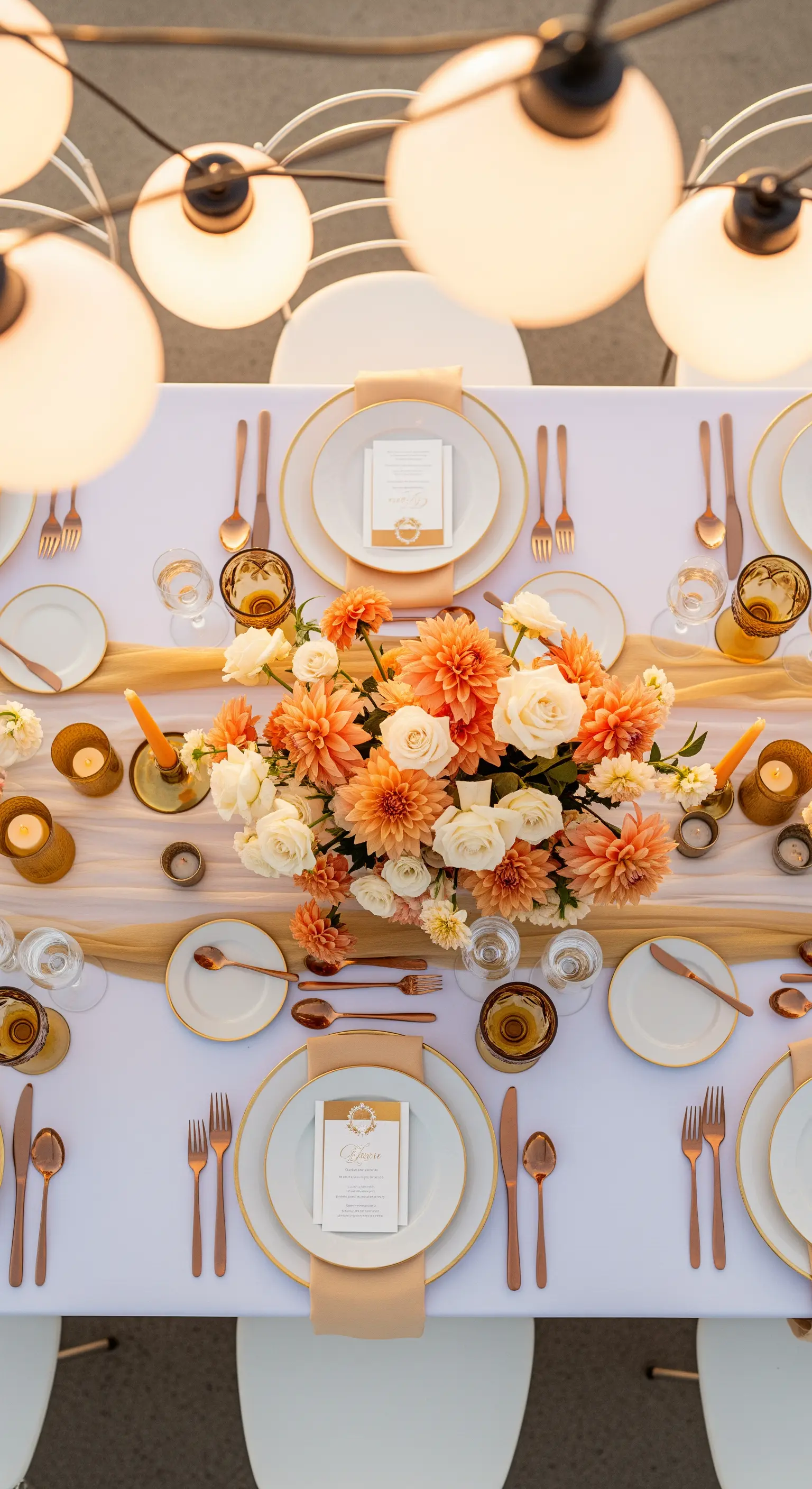 Tavola elegante vista dall'alto con fiori arancioni, posate e runner dorati.