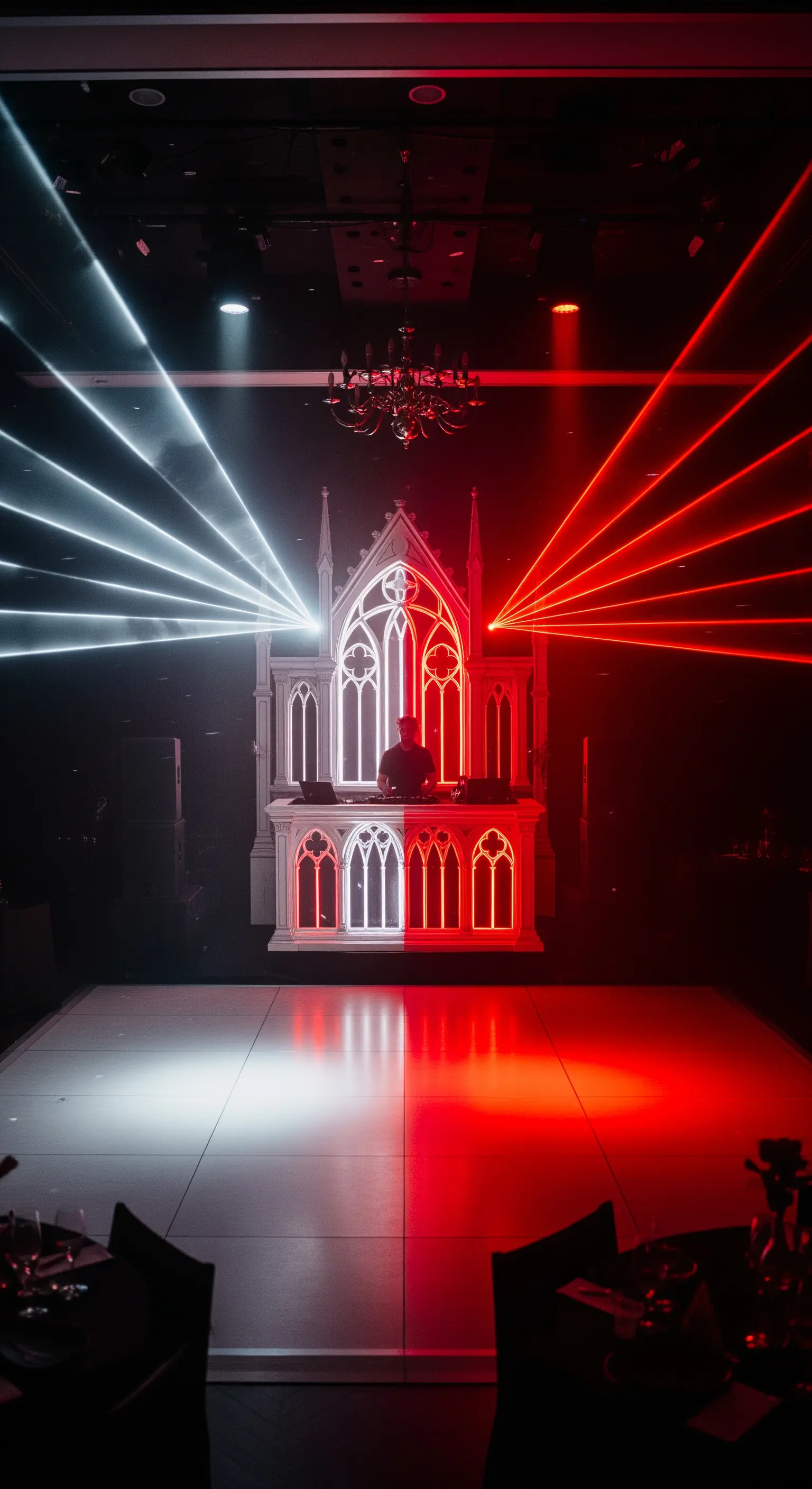 DJ booth a forma di cattedrale gotica con laser rossi e bianchi.