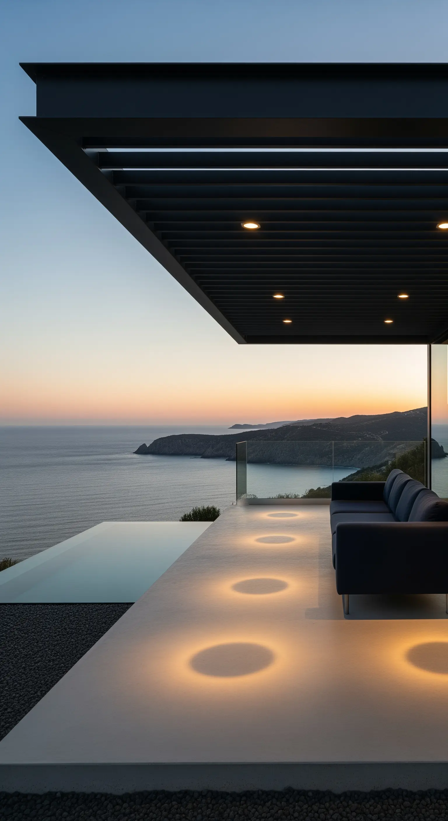 Terrazza con vista mare e cerchi di luce calda incassati nel pavimento in cemento bianco