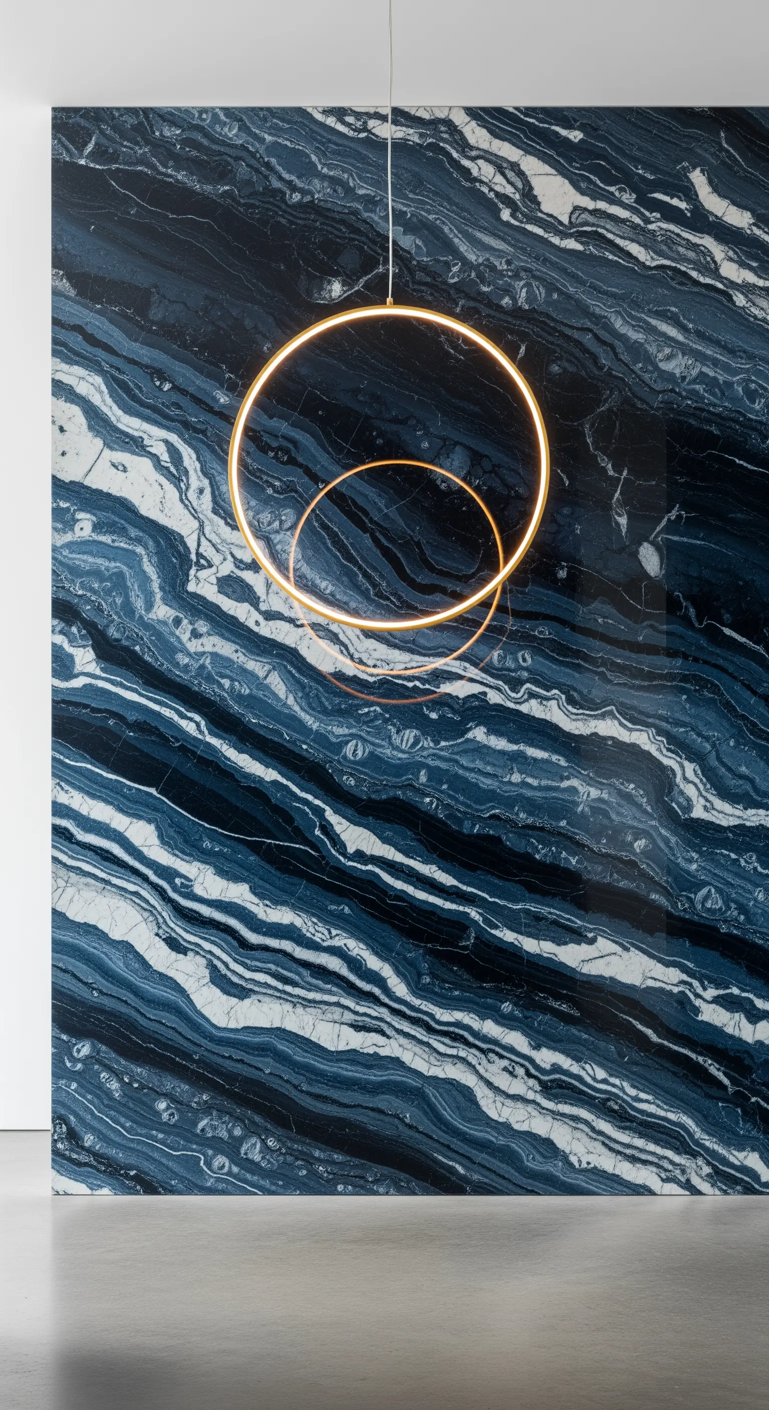 Parete in marmo blu con venature ondulate e due lampade a sospensione circolari dorate.