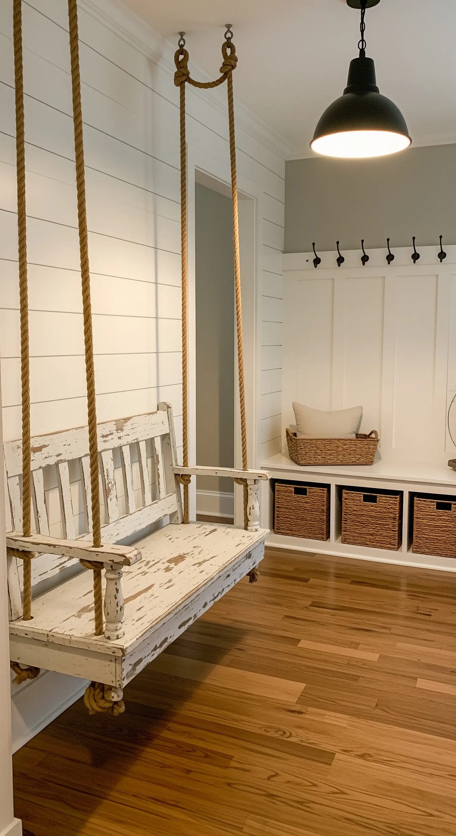 Panca sospesa in legno bianco decapato in un ingresso in stile farmhouse.