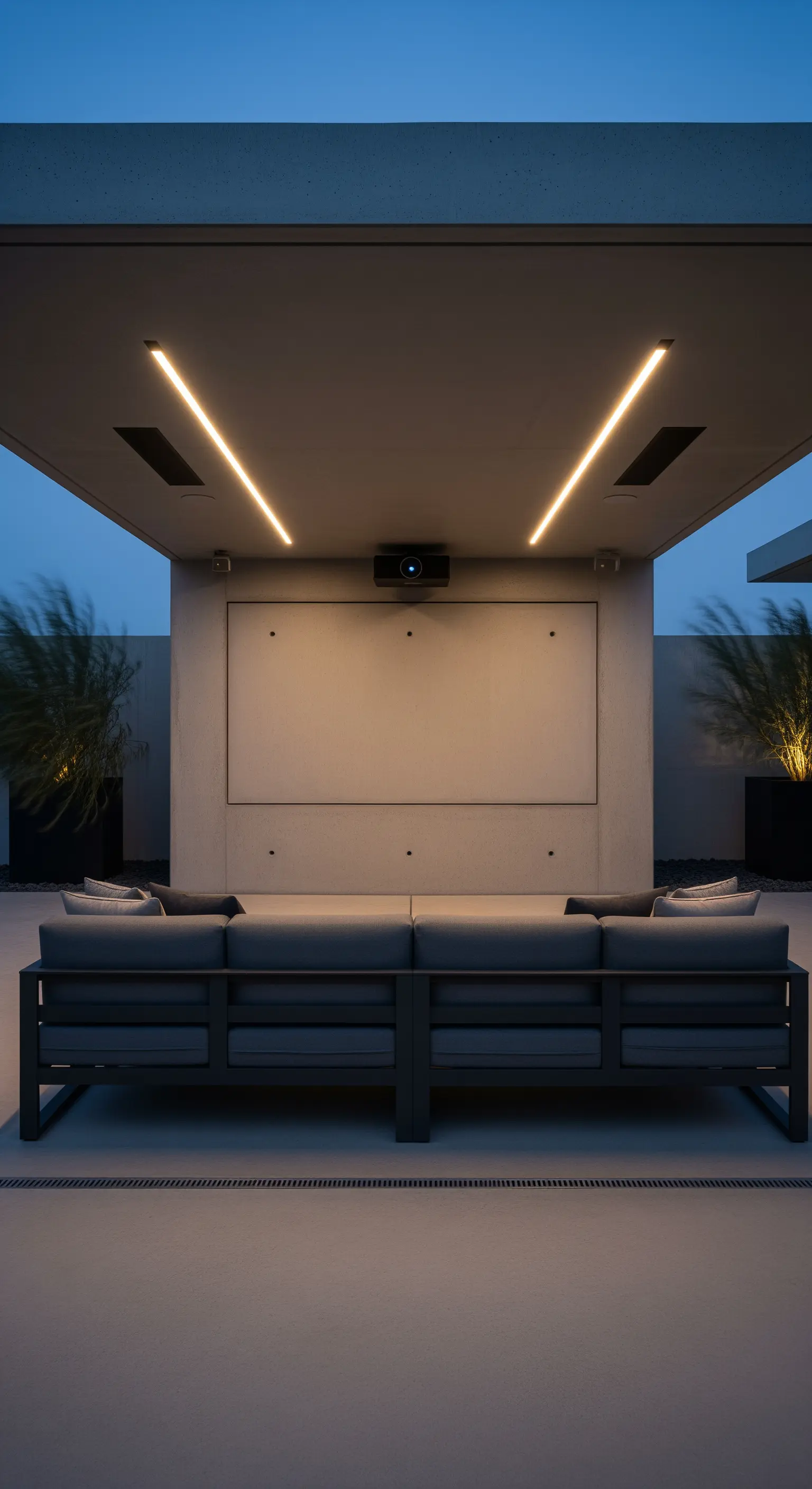 Portico moderno allestito come cinema all'aperto, con proiettore e divano rivolto verso lo schermo