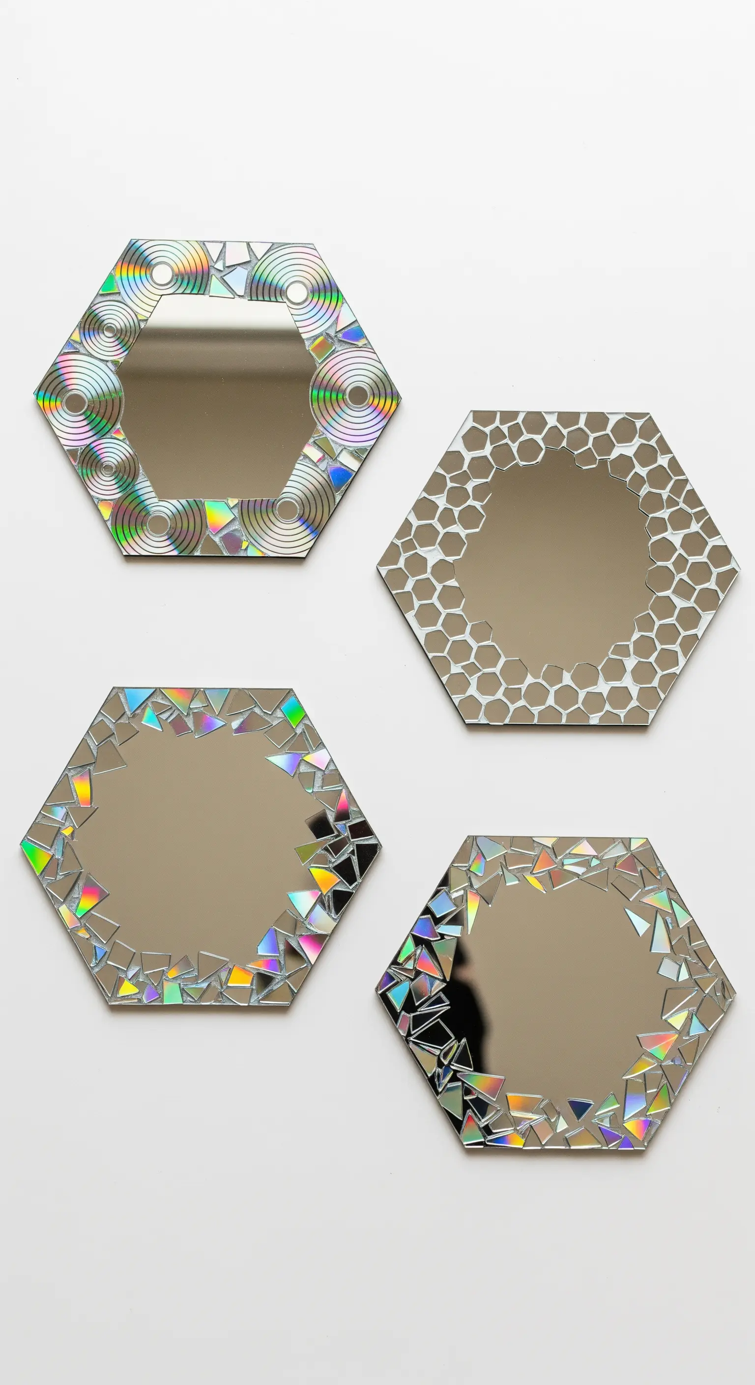 Quattro specchi esagonali appesi a una parete bianca, ognuno con una diversa decorazione a mosaico.