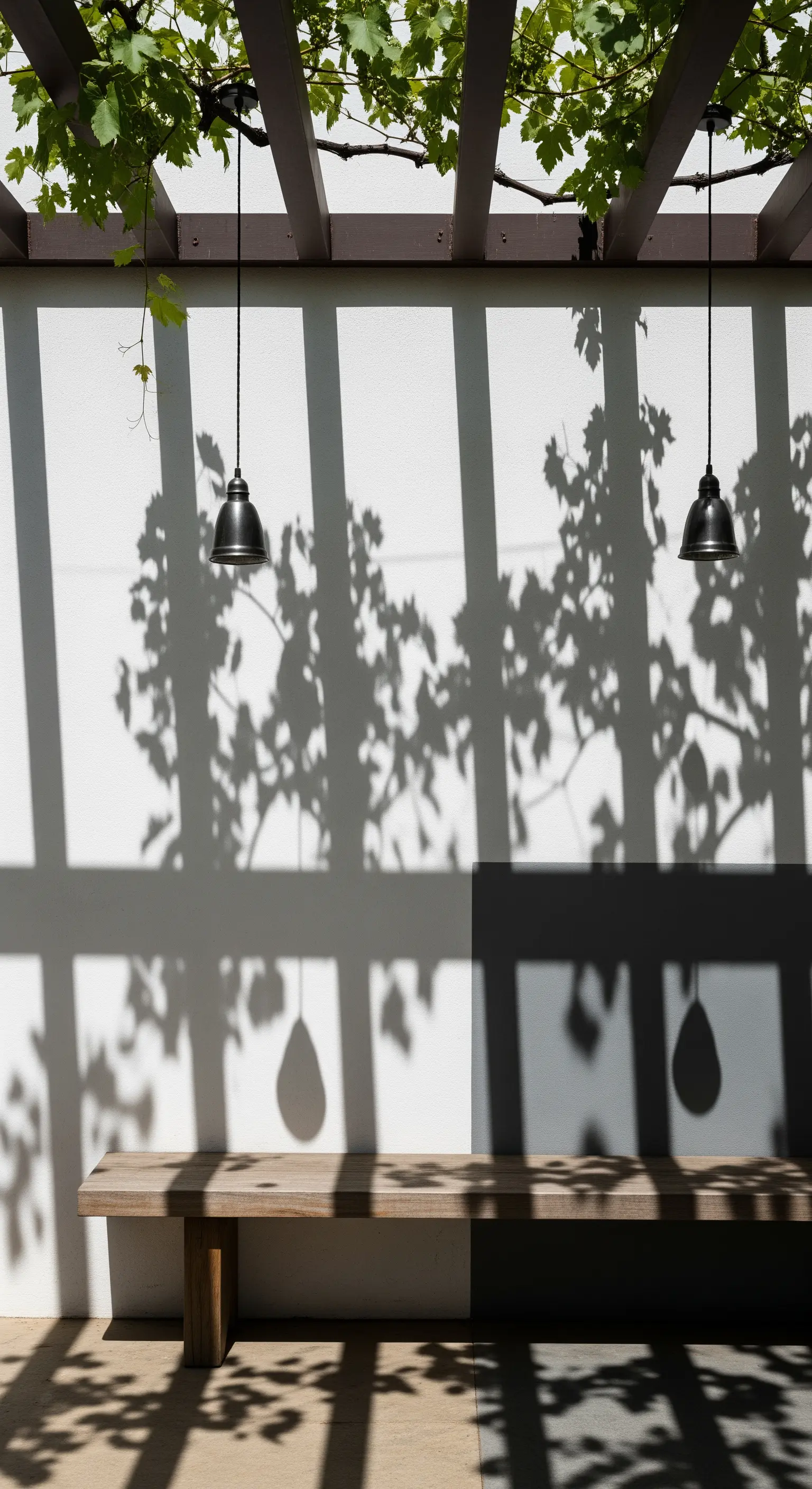 Panca in legno e due lampade nere le cui ombre si proiettano su una parete bianca