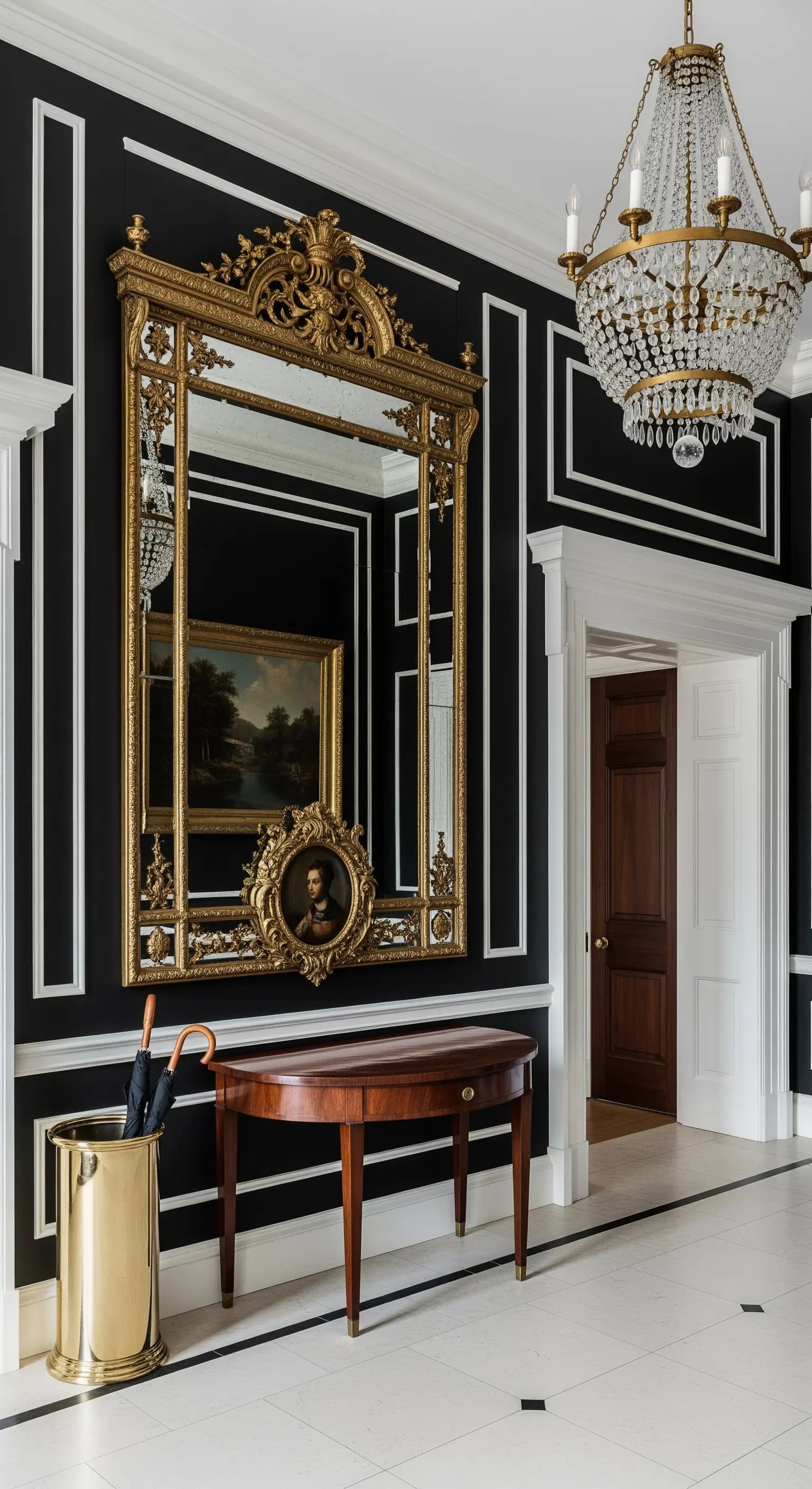 Parete nera con boiserie bianca, specchio antico dorato e lampadario di cristallo.