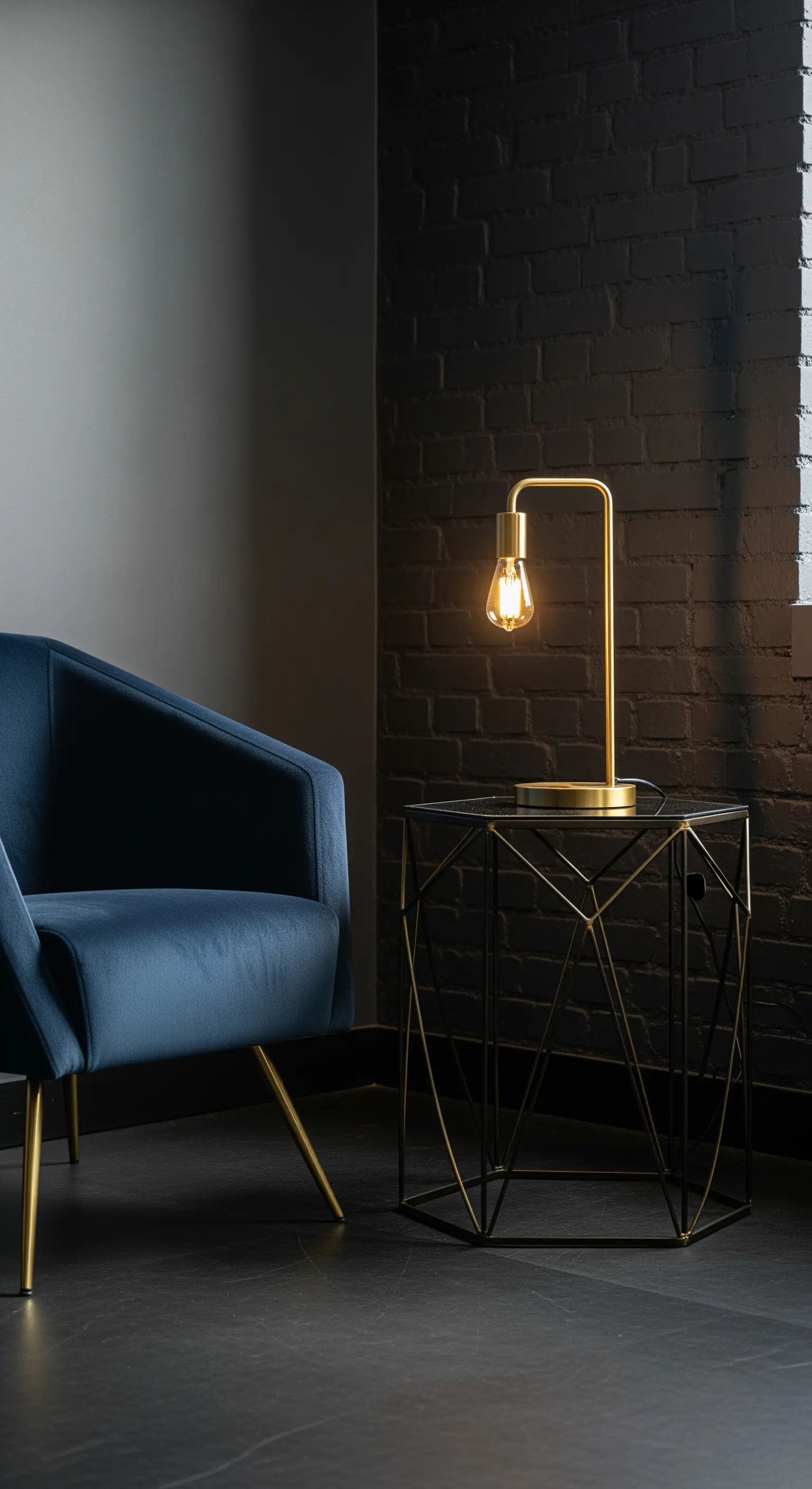 Poltrona in velluto blu vicino a un muro di mattoni neri e un tavolino geometrico.