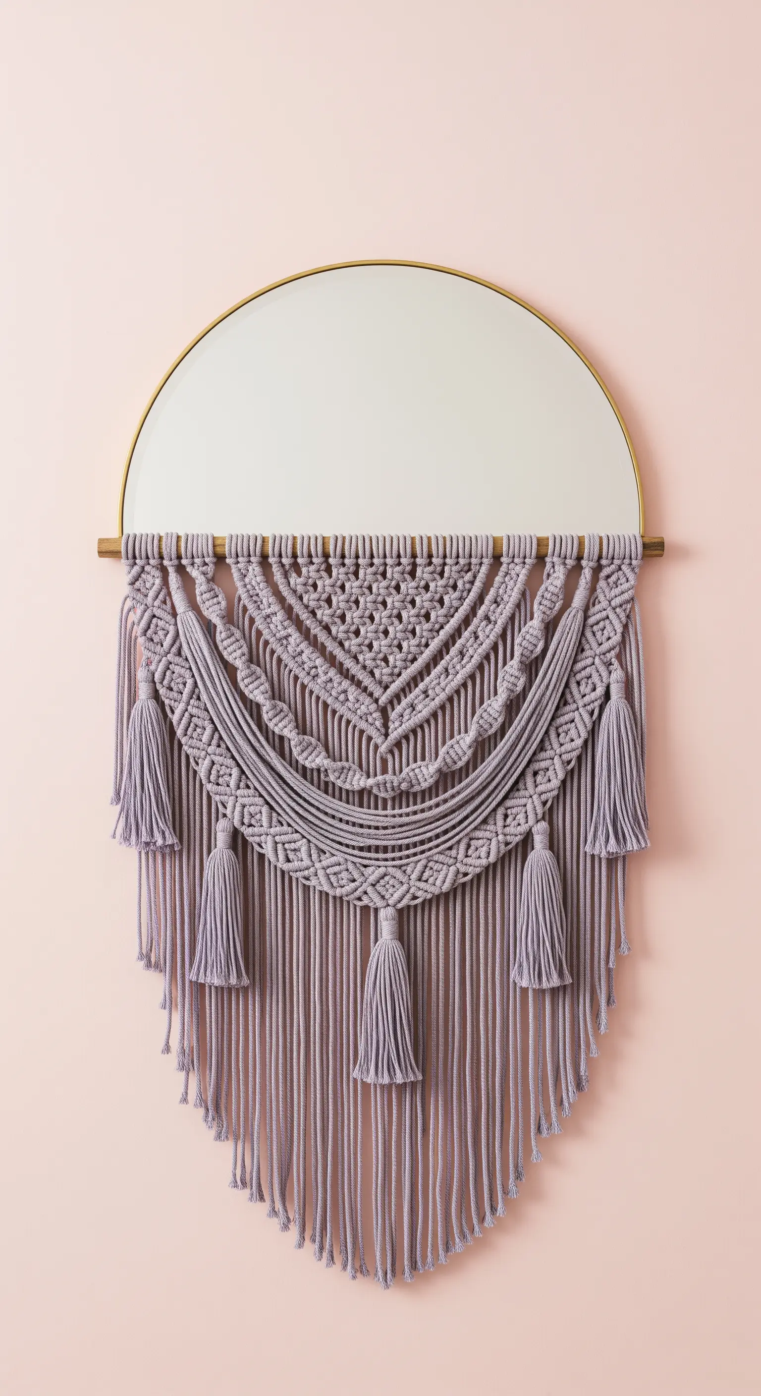Decorazione in macramè color lavanda che incornicia la parte inferiore di uno specchio a semicerchio.