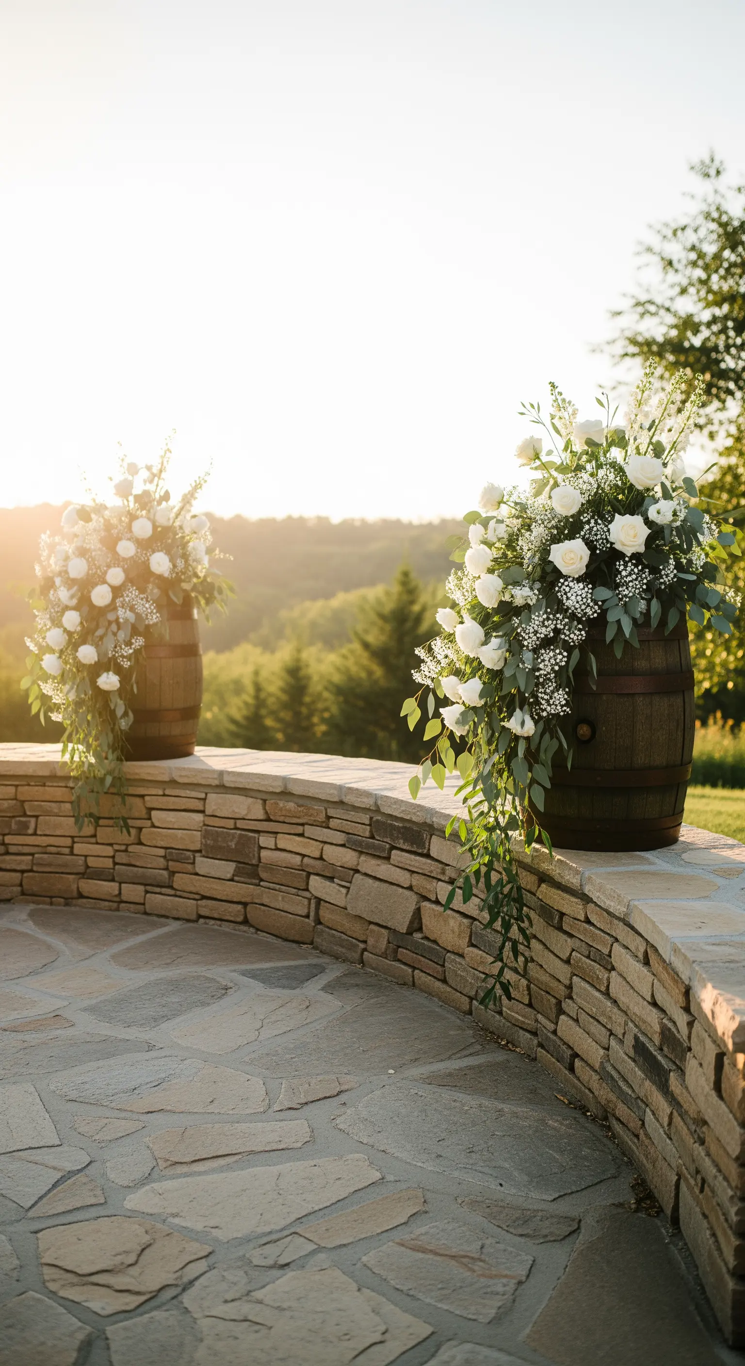 Due botti con eleganti e ampie composizioni di fiori bianchi su una terrazza panoramica.