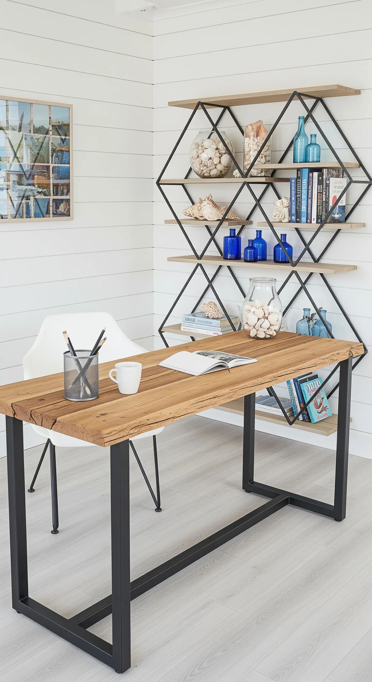 Studio in stile costiero con libreria geometrica in metallo nero e legno chiaro su parete perlinata.