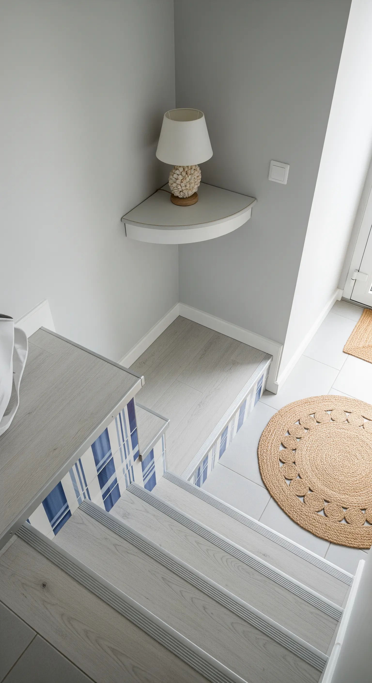 Vista dall'alto di una scala con alzate decorate con un motivo a righe blu e bianche.