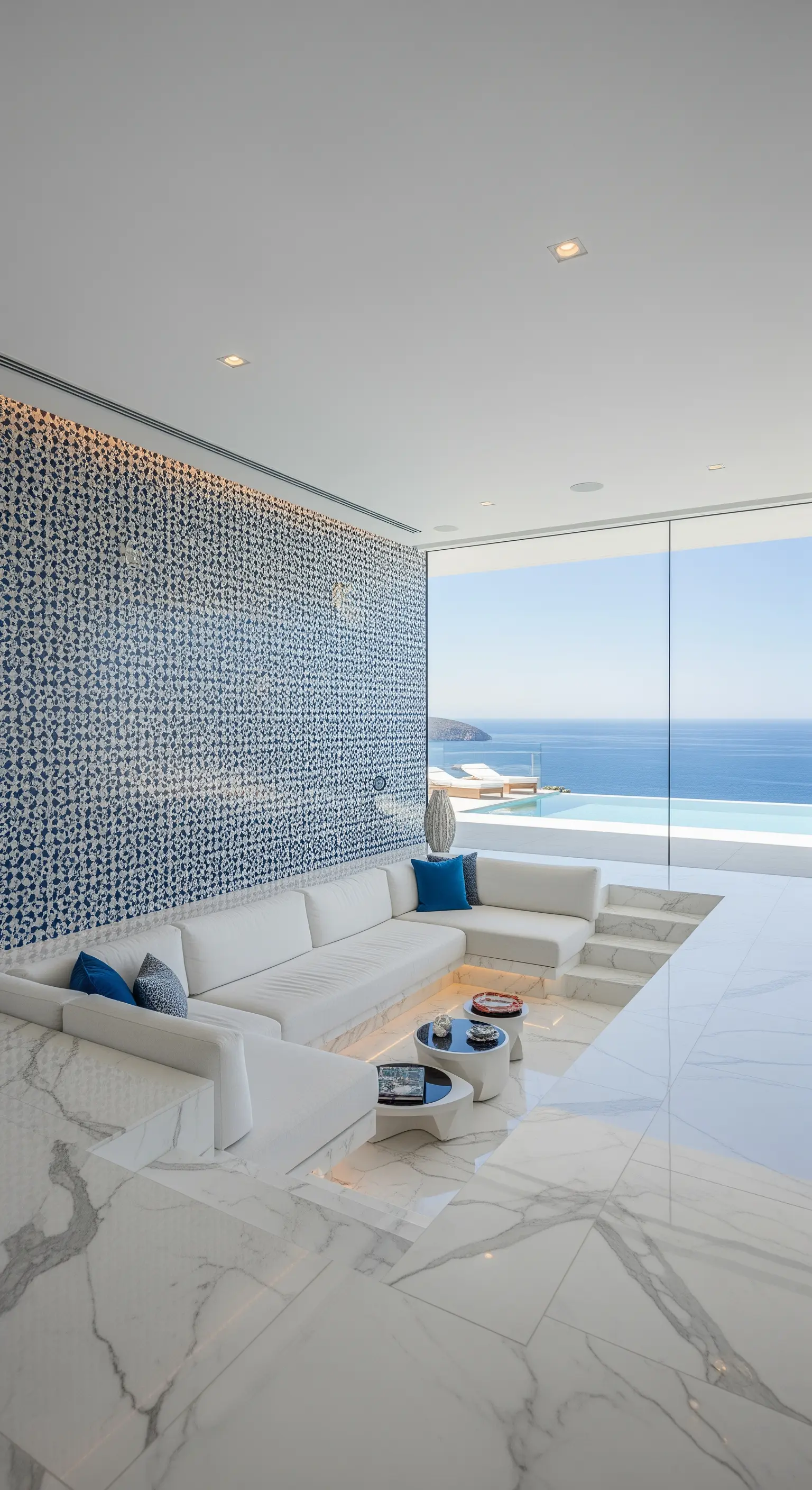Salotto moderno incassato con divani bianchi e una parete a mosaico blu e bianco.