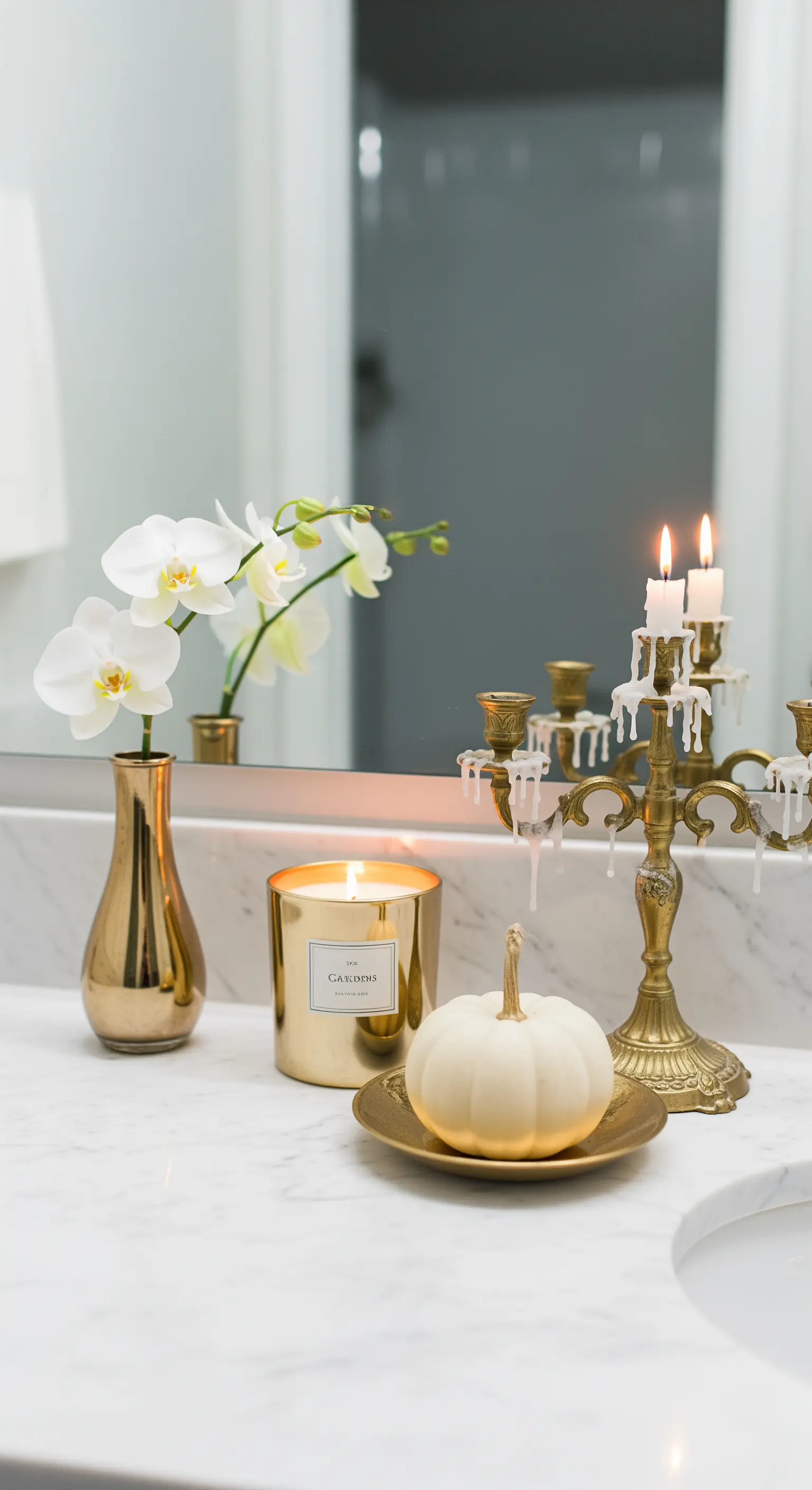 Angolo bagno con candelabro dorato, zucca bianca e orchidea